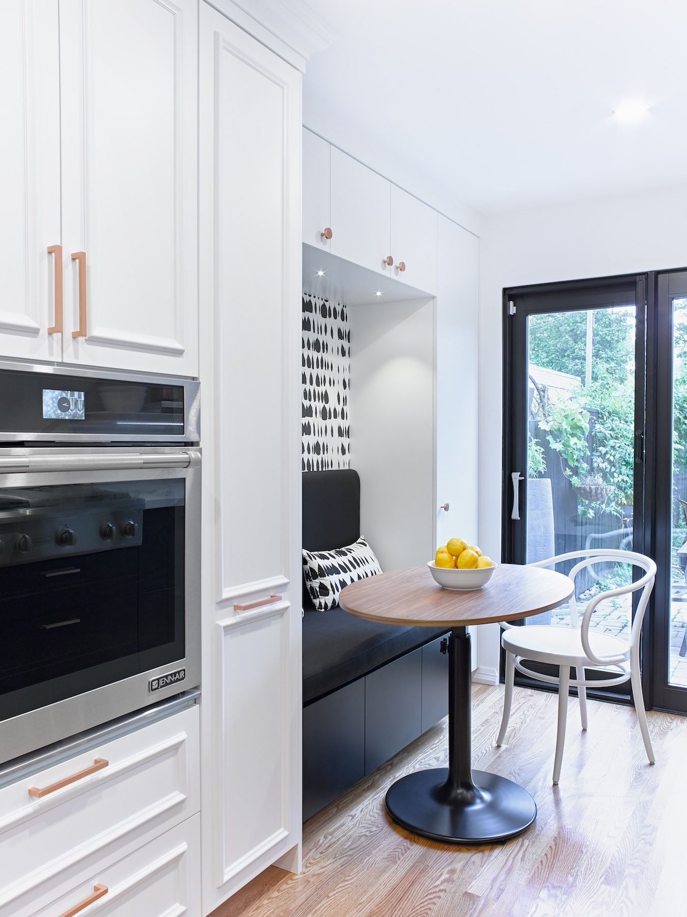 A kitchen with a table and chairs and a sliding glass door.