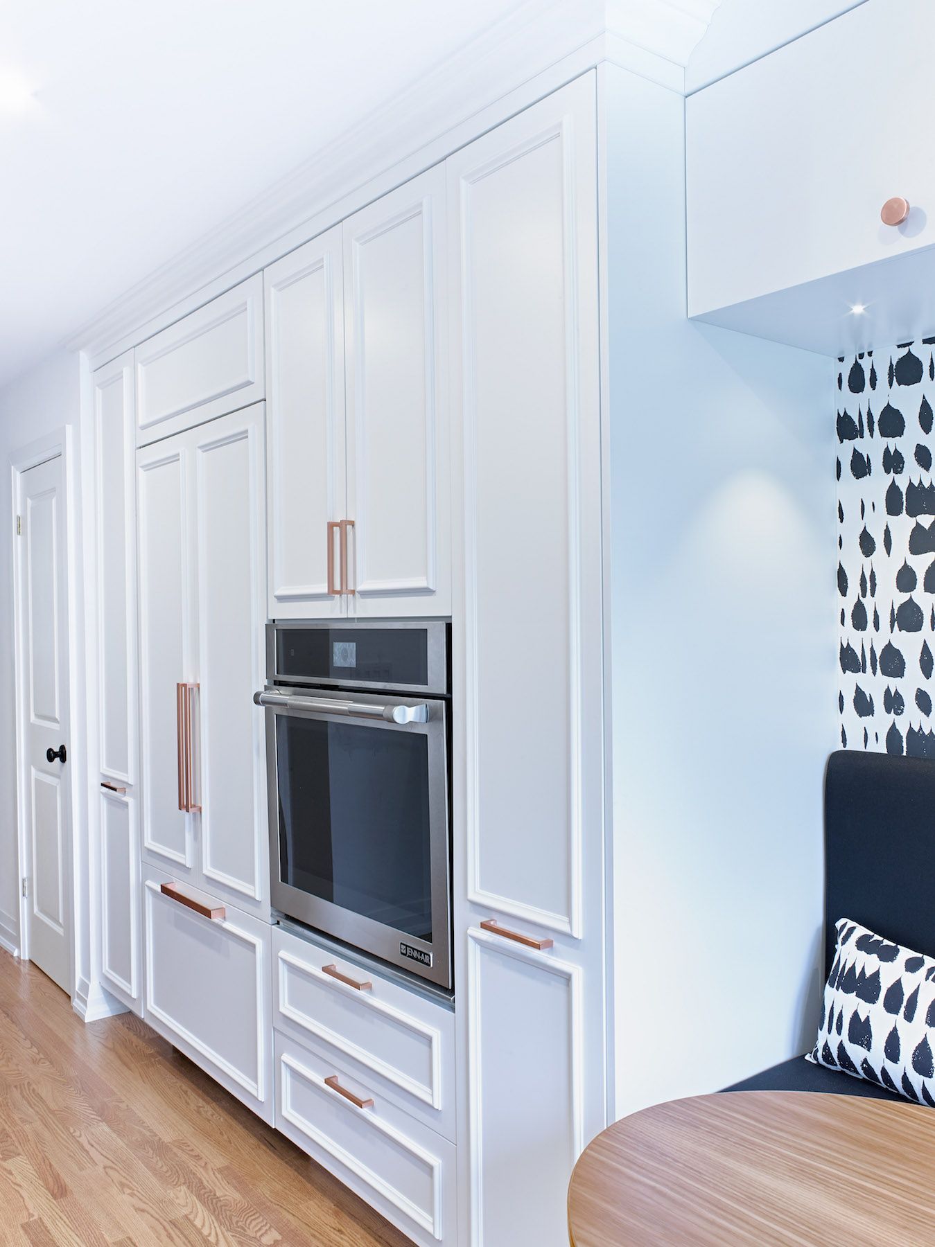 A kitchen with white cabinets and a stainless steel oven.
