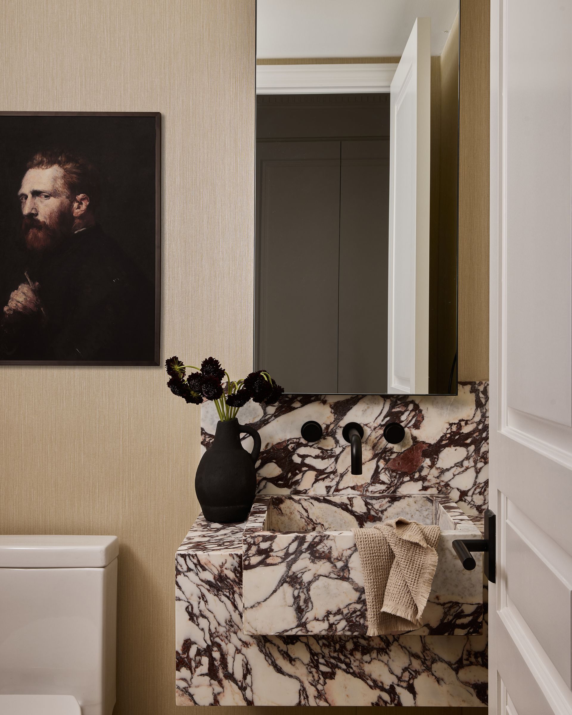 A bathroom with a sink and a painting on the wall