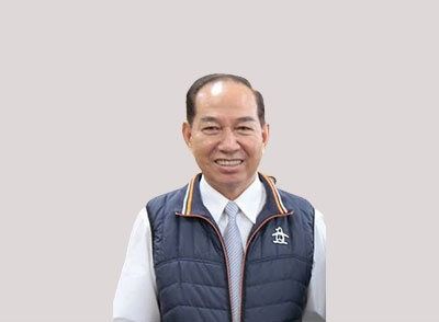 一名身穿背心和領帶的男子正對著鏡頭微笑。