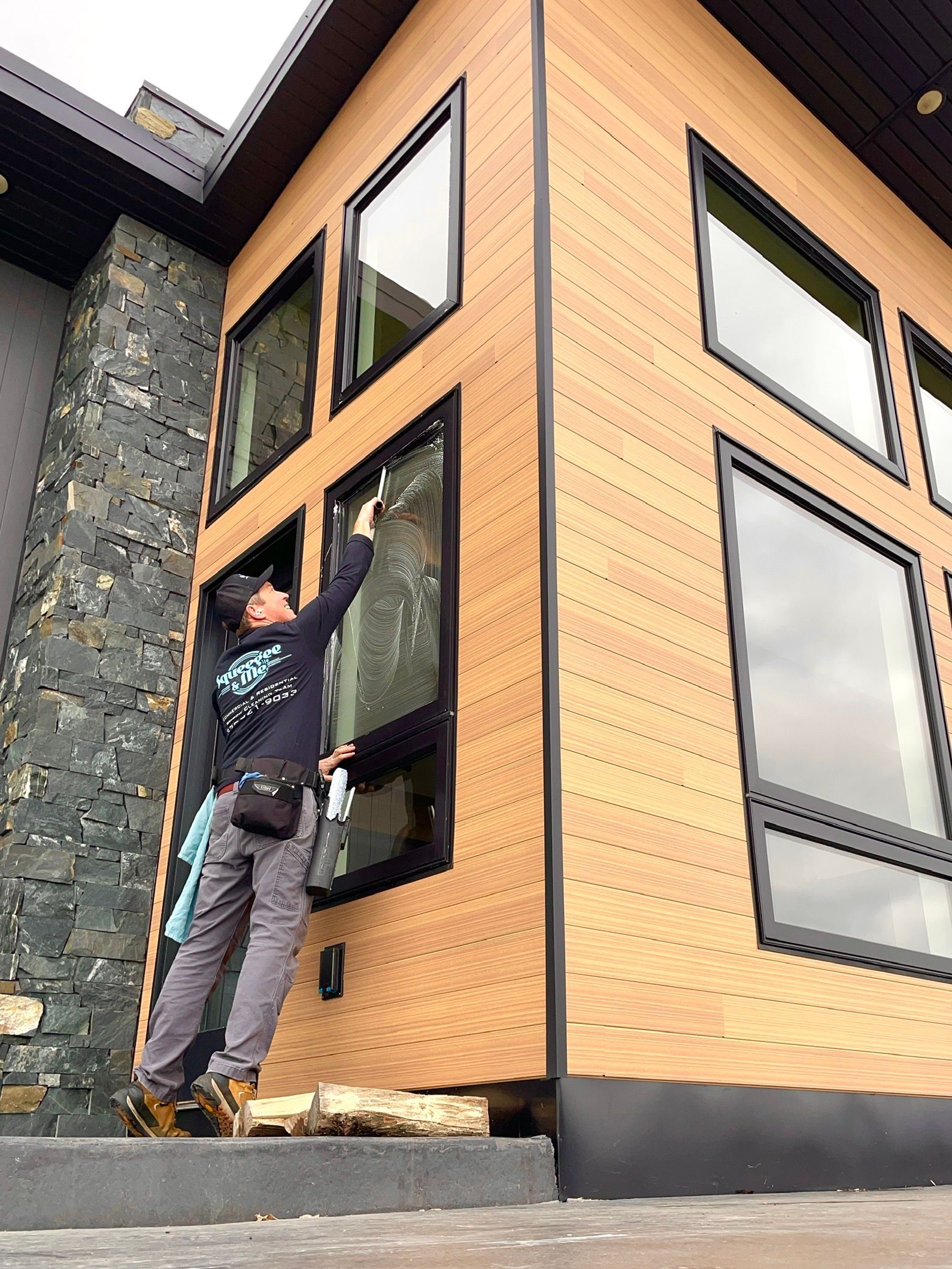 A man is cleaning a window on the side of a building.