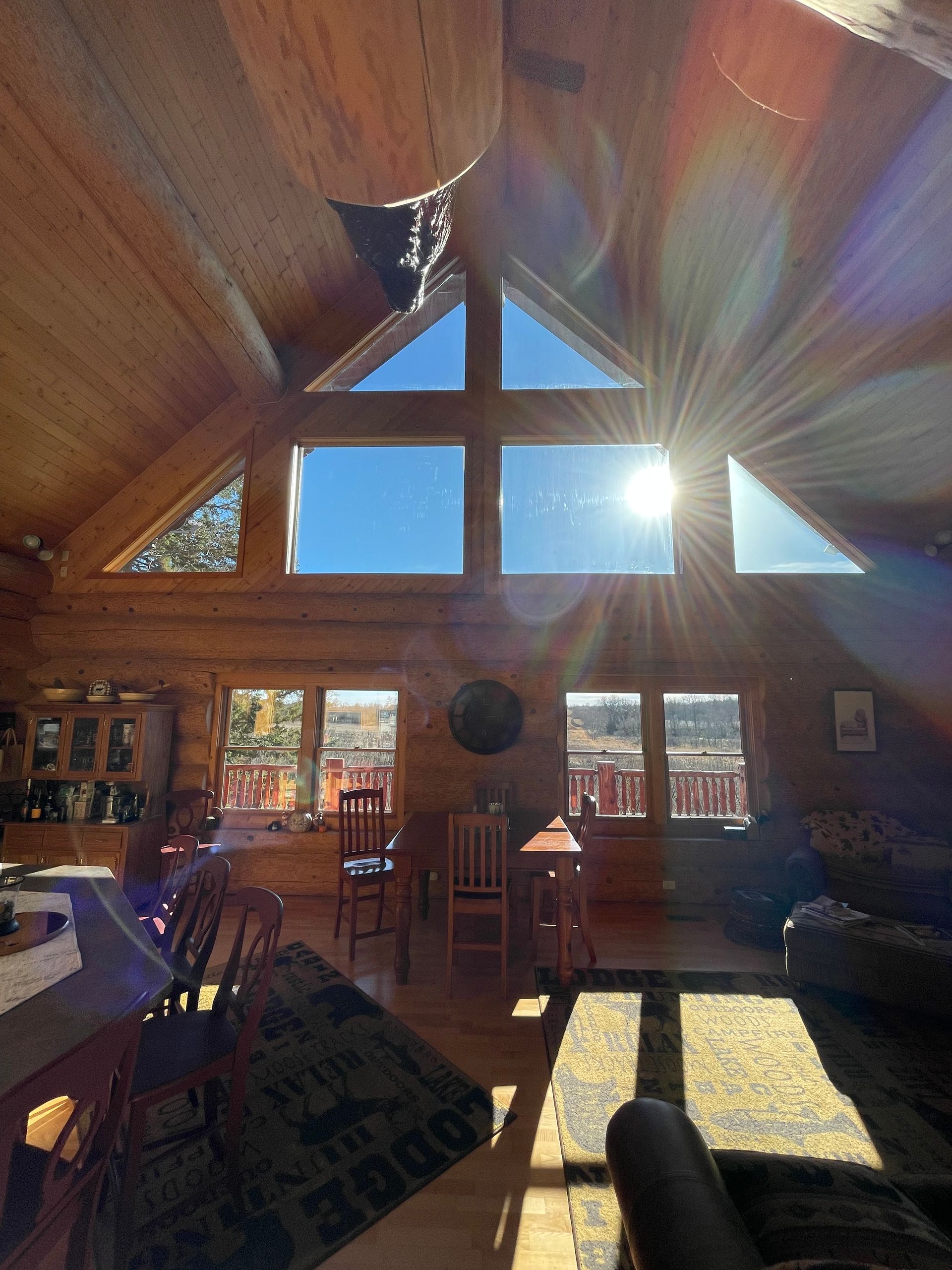 The sun is shining through the windows of a log cabin