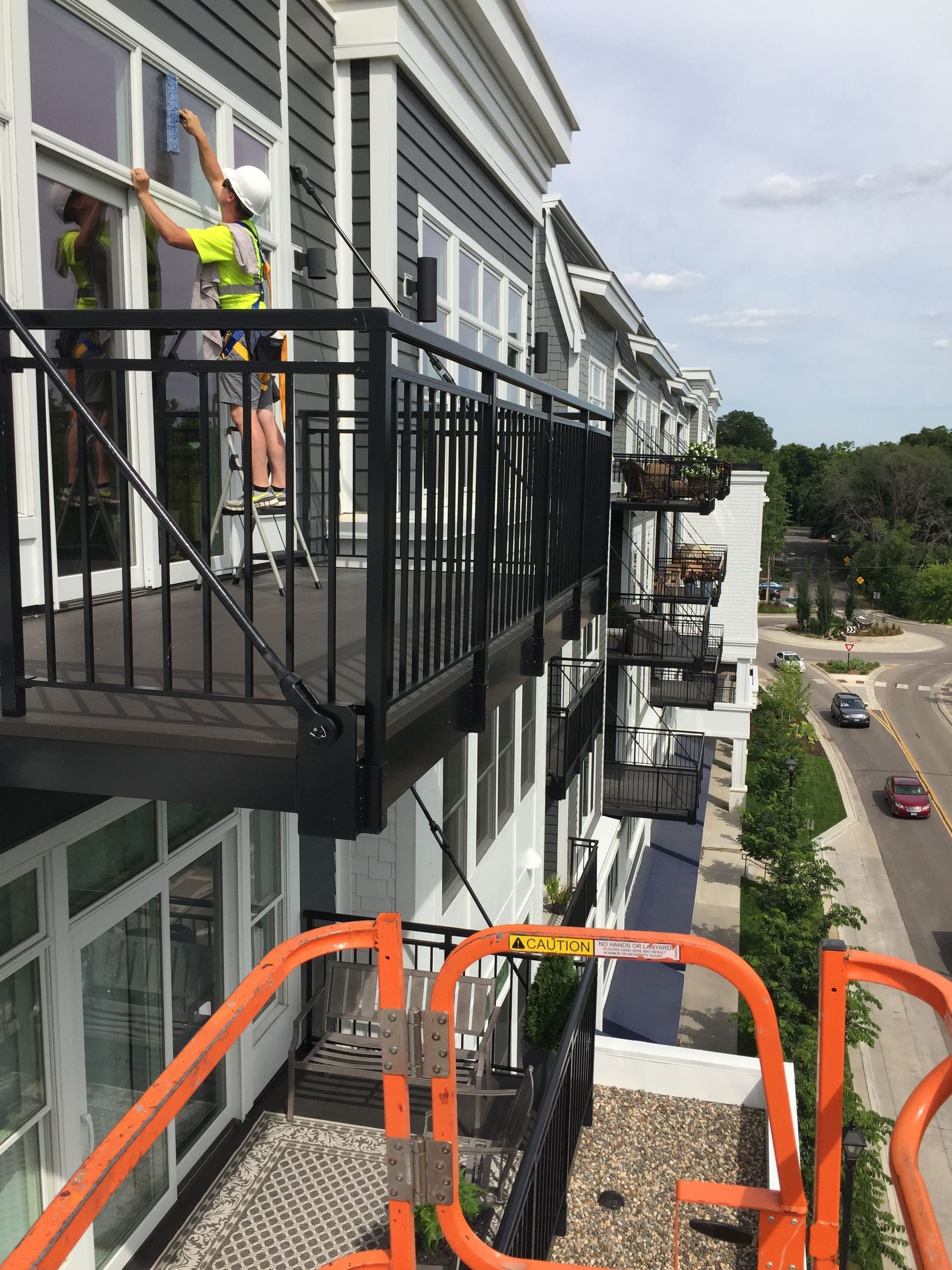 A man is cleaning windows on a balcony of a building.