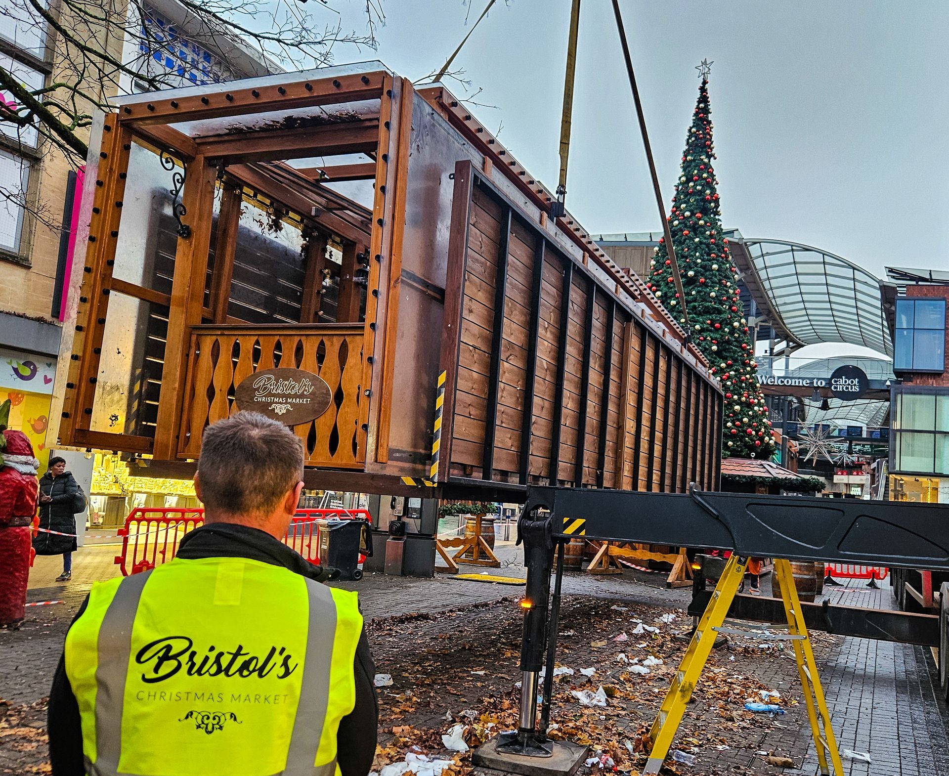 A man wearing a yellow vest that says bristol 's on it