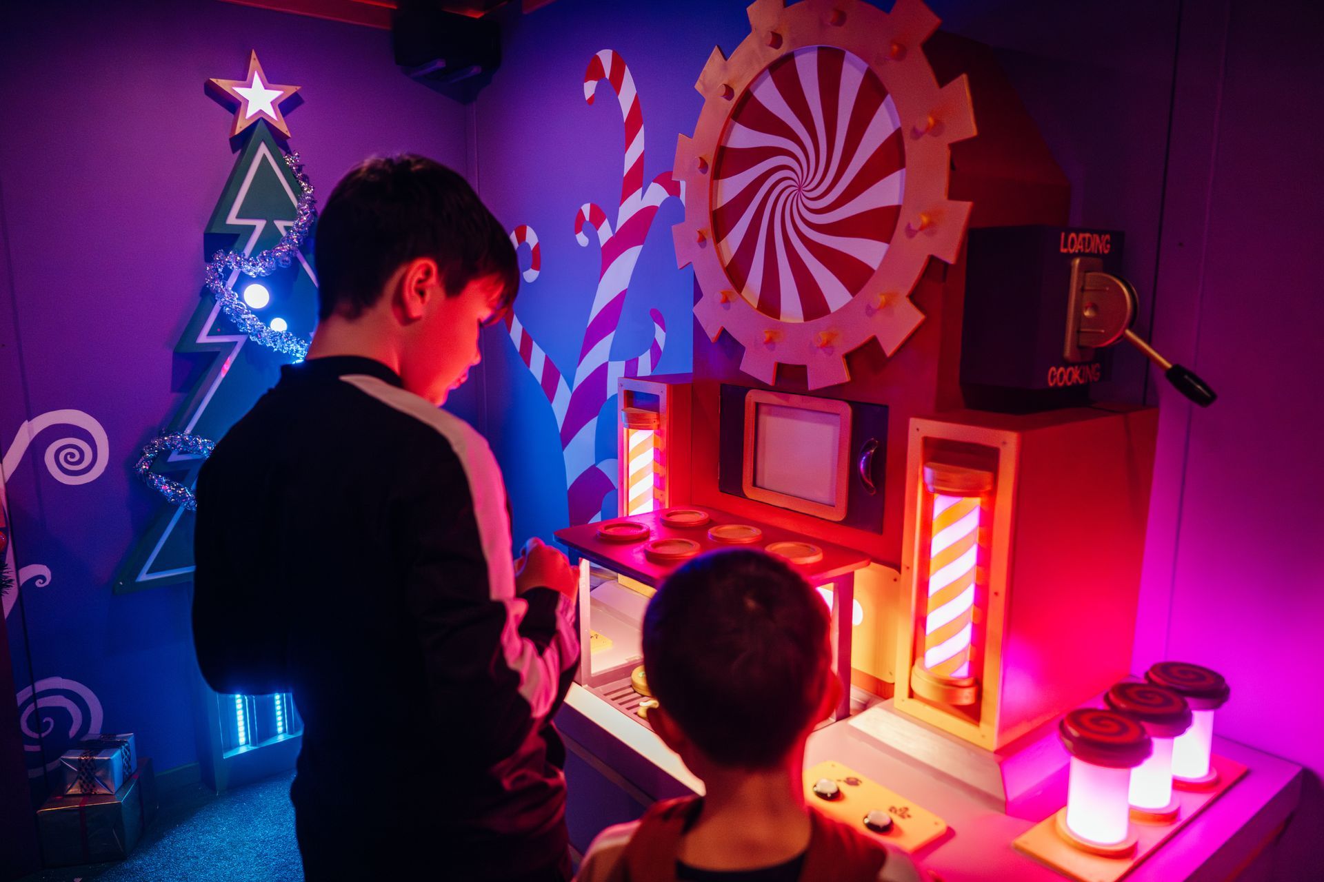 Two young boys are playing a game in a room decorated for christmas