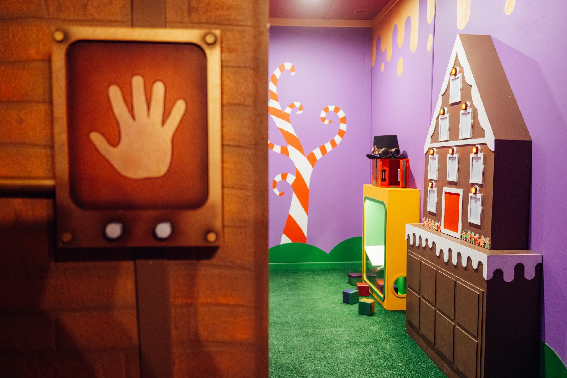 A room with a gingerbread house and candy canes on the wall