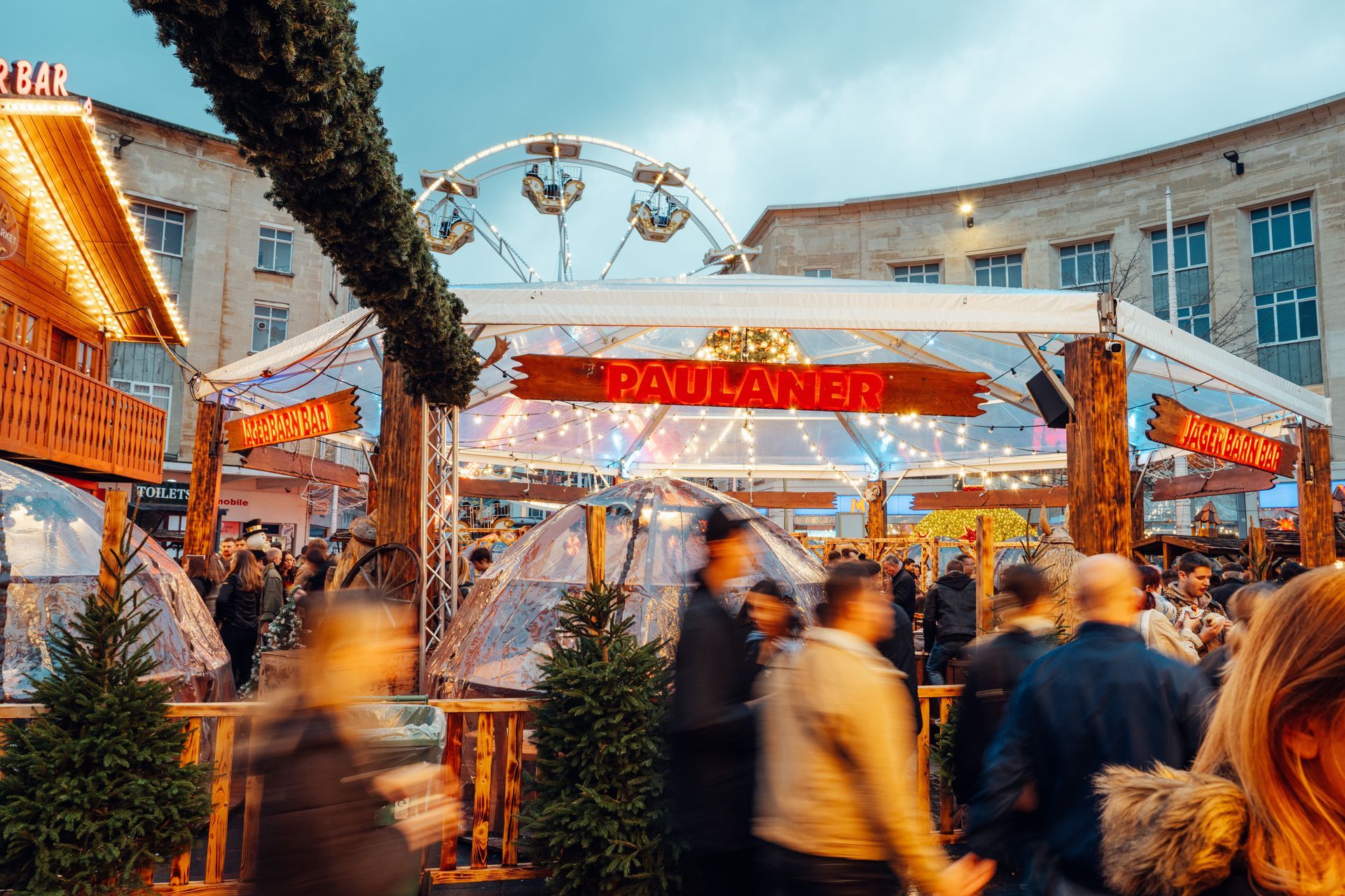 A crowd of people are walking in front of a sign that says boulaner