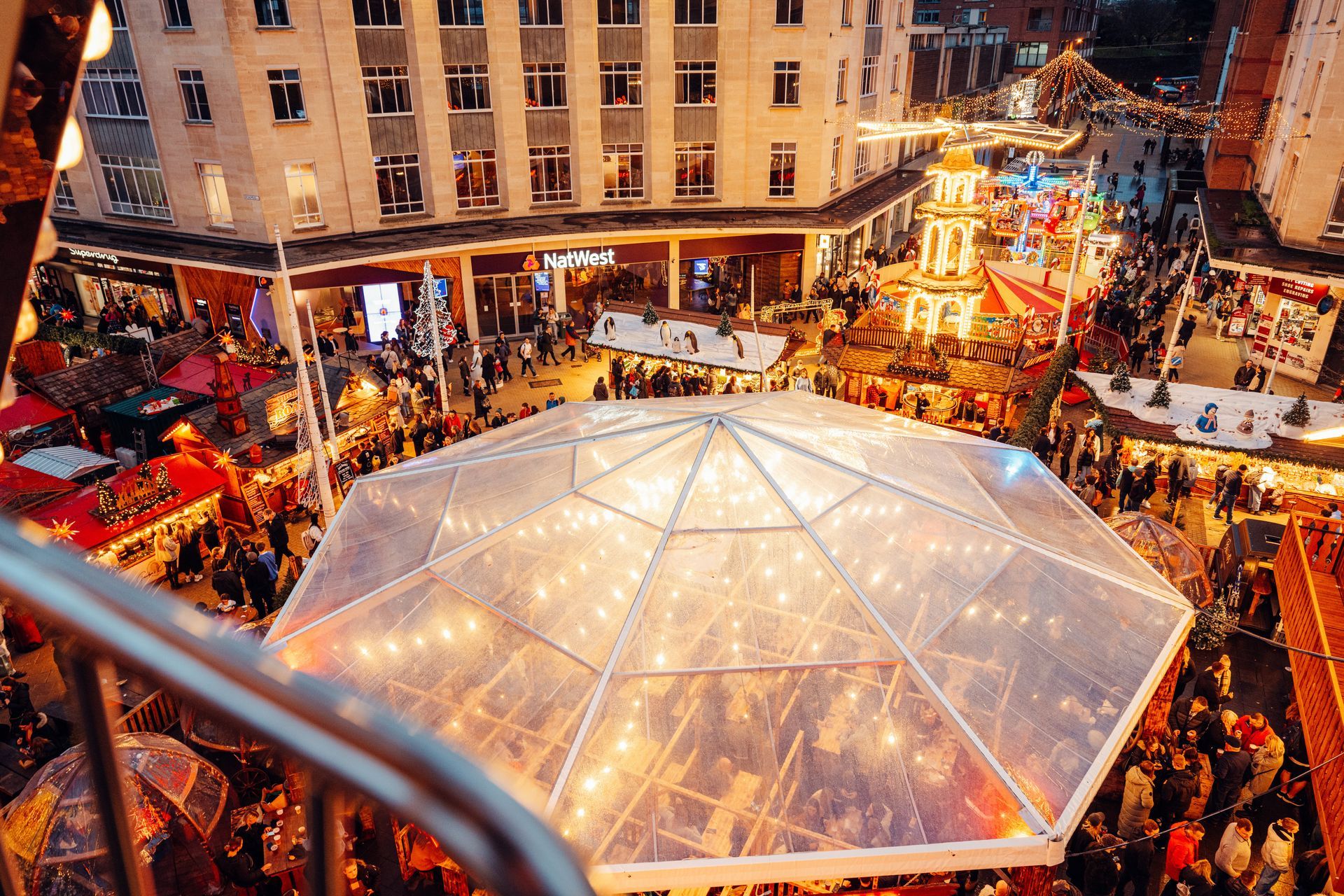 An aerial view of a christmas market with a clear dome in the middle