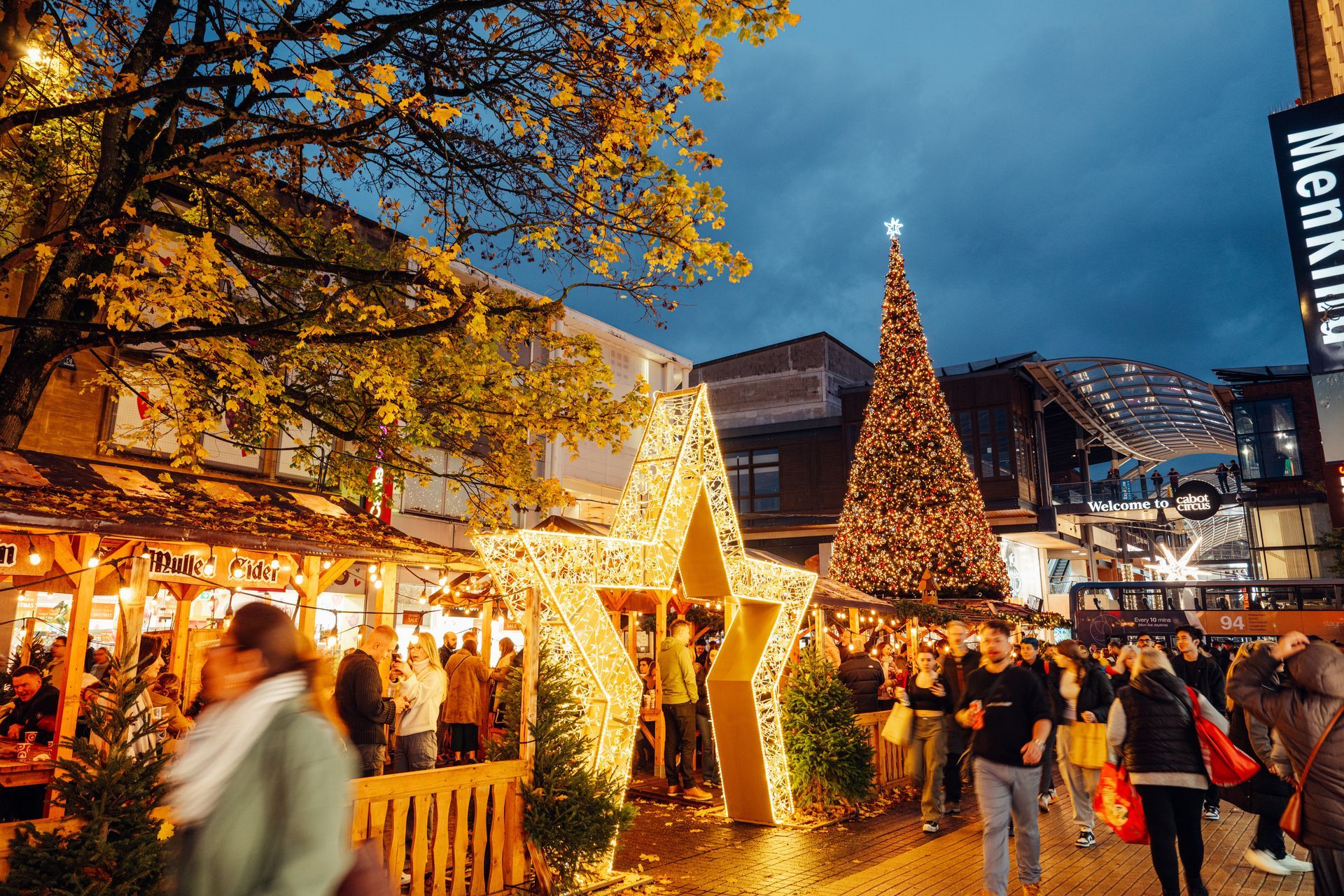 A group of people are walking around a christmas market