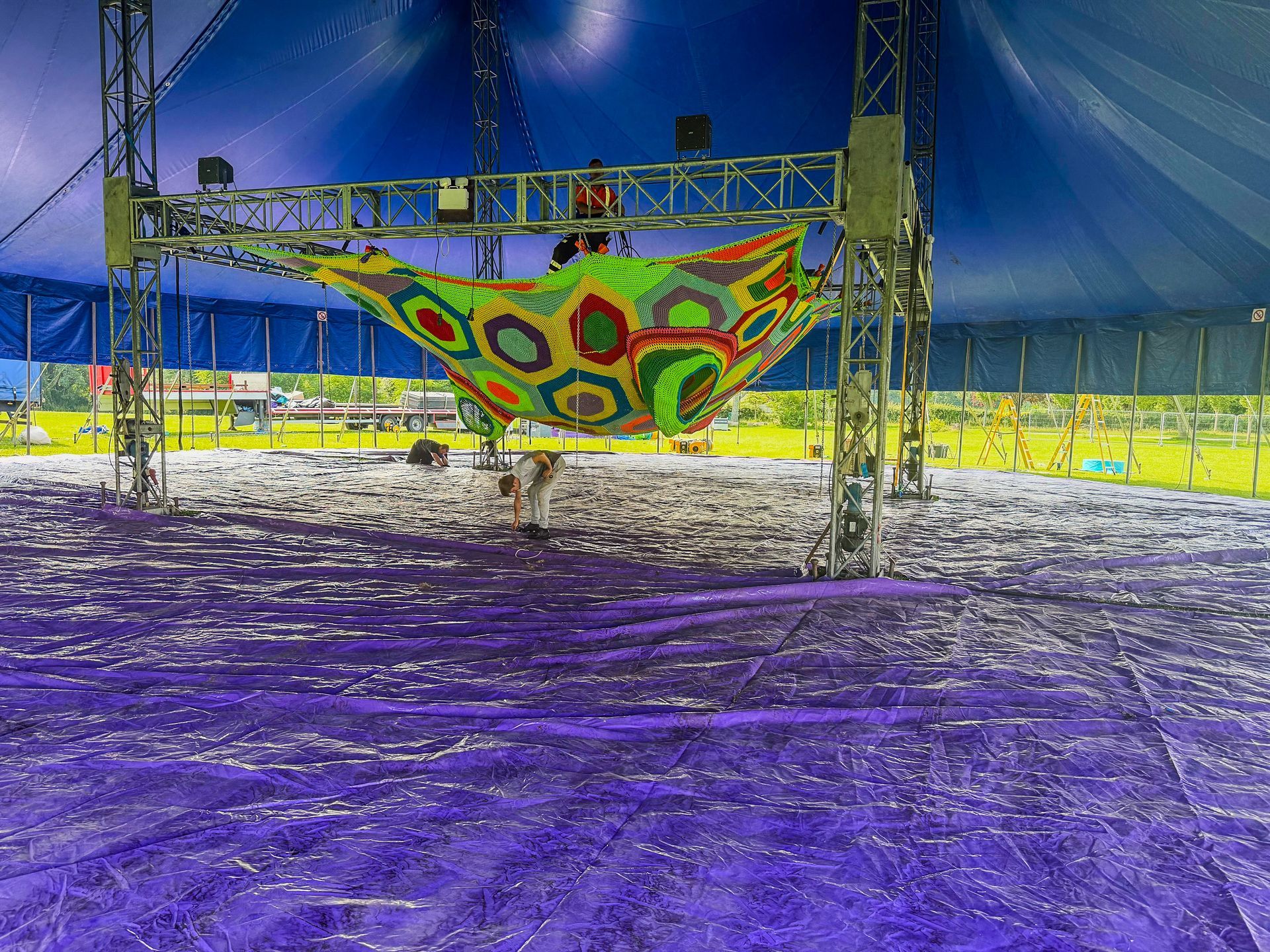 A colorful hammock is hanging from the ceiling of a tent