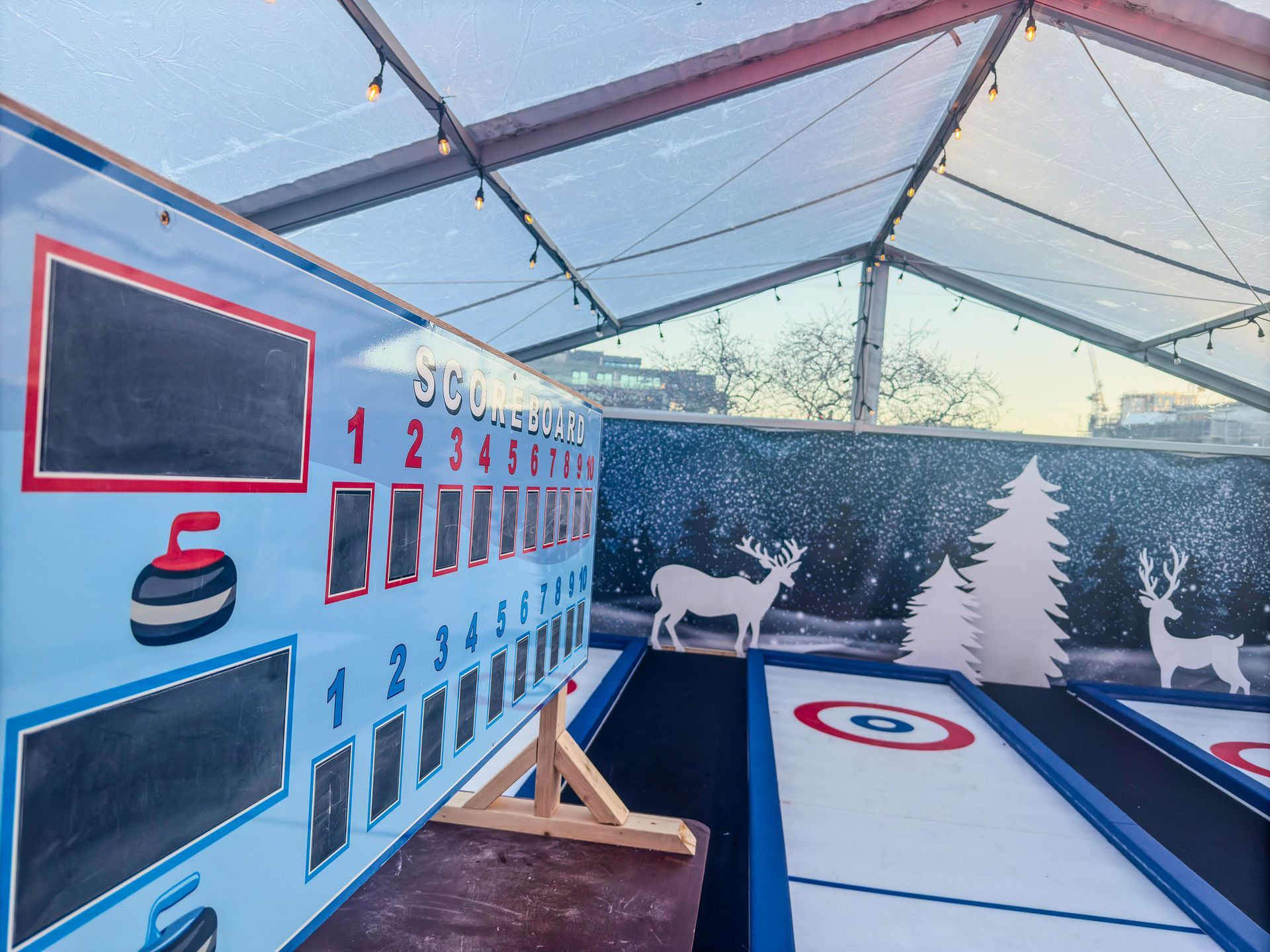 A game of curling is being played under a clear tent