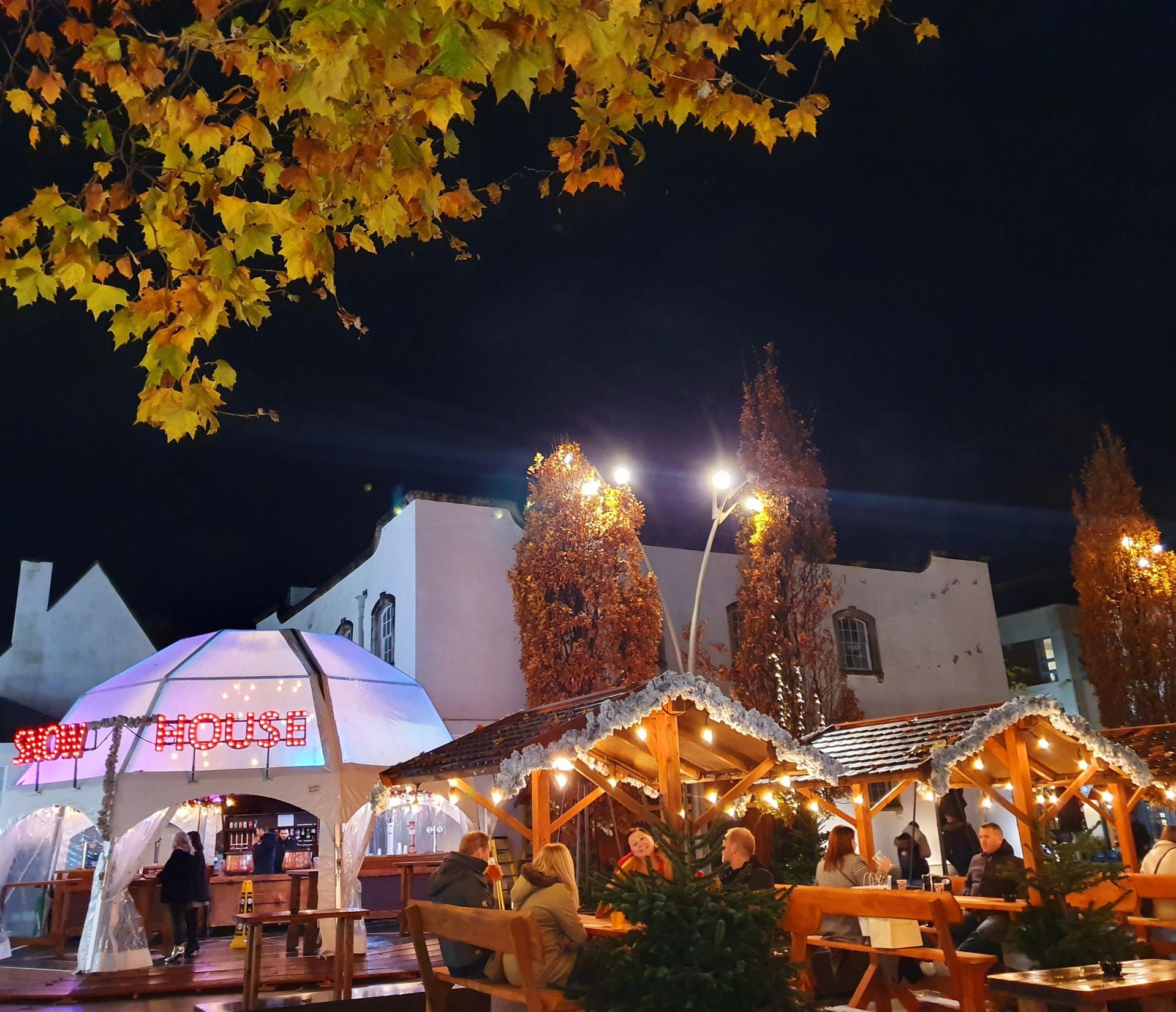 A group of people are sitting under a dome that says ' coca cola ' on it