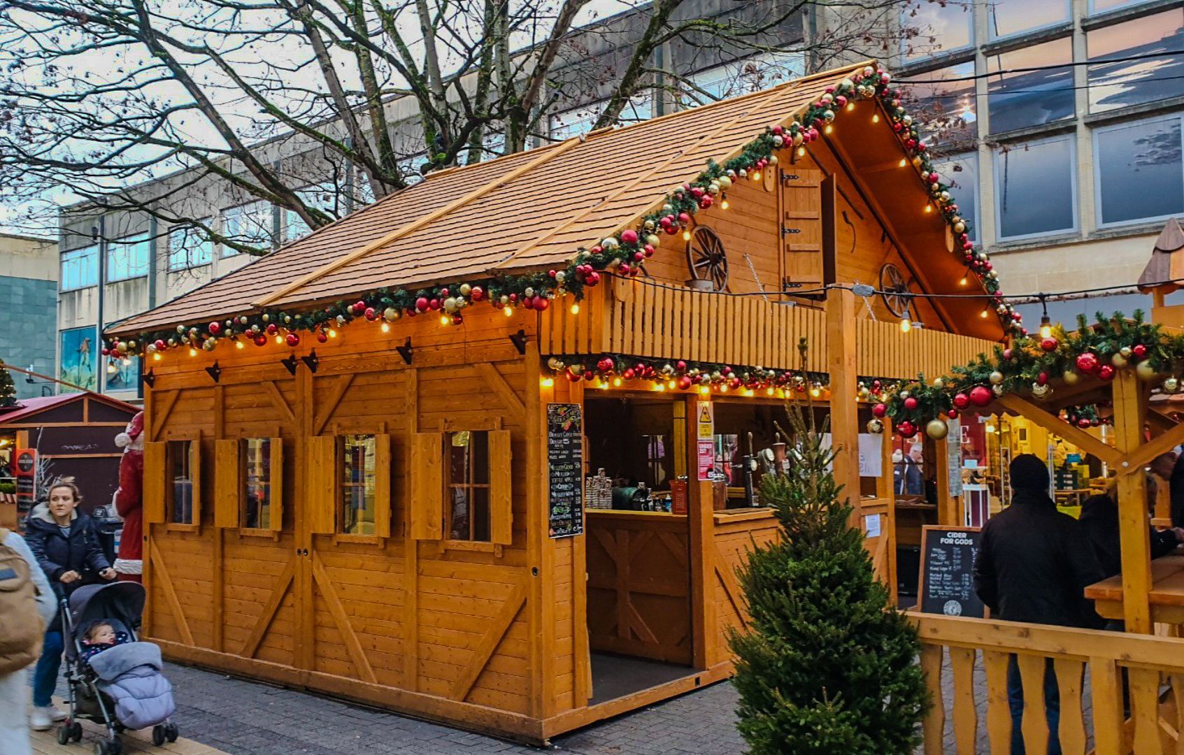 A wooden building with a roof decorated with christmas lights