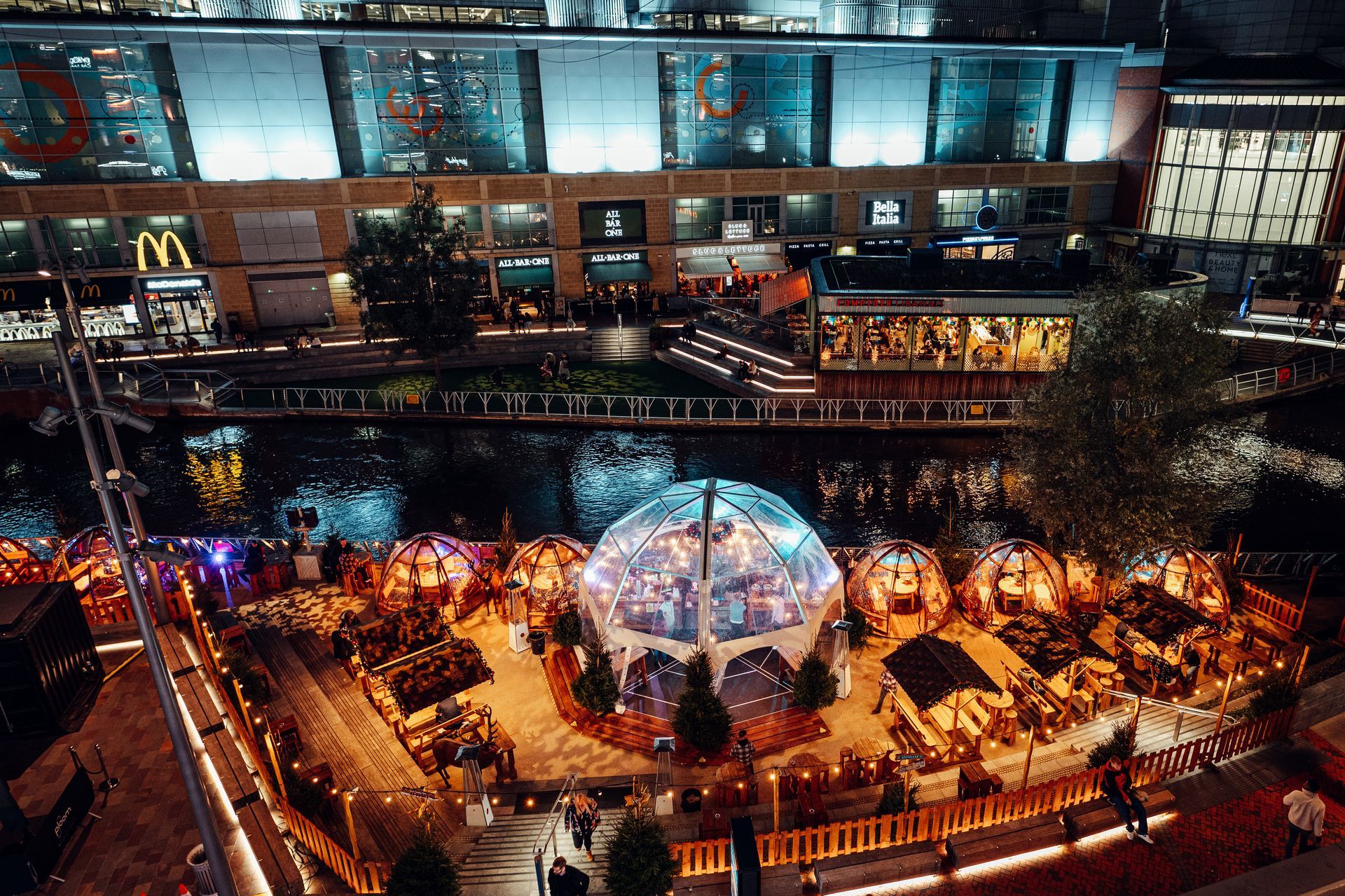 An aerial view of a city at night with a mcdonald 's in the background