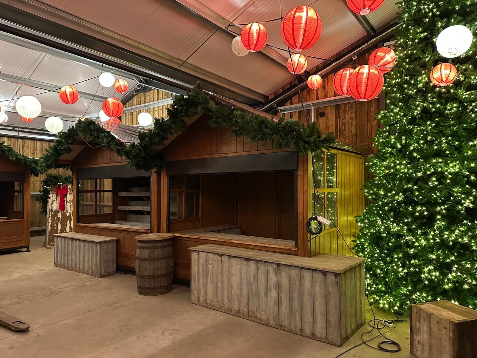 A room with a christmas tree and lanterns hanging from the ceiling