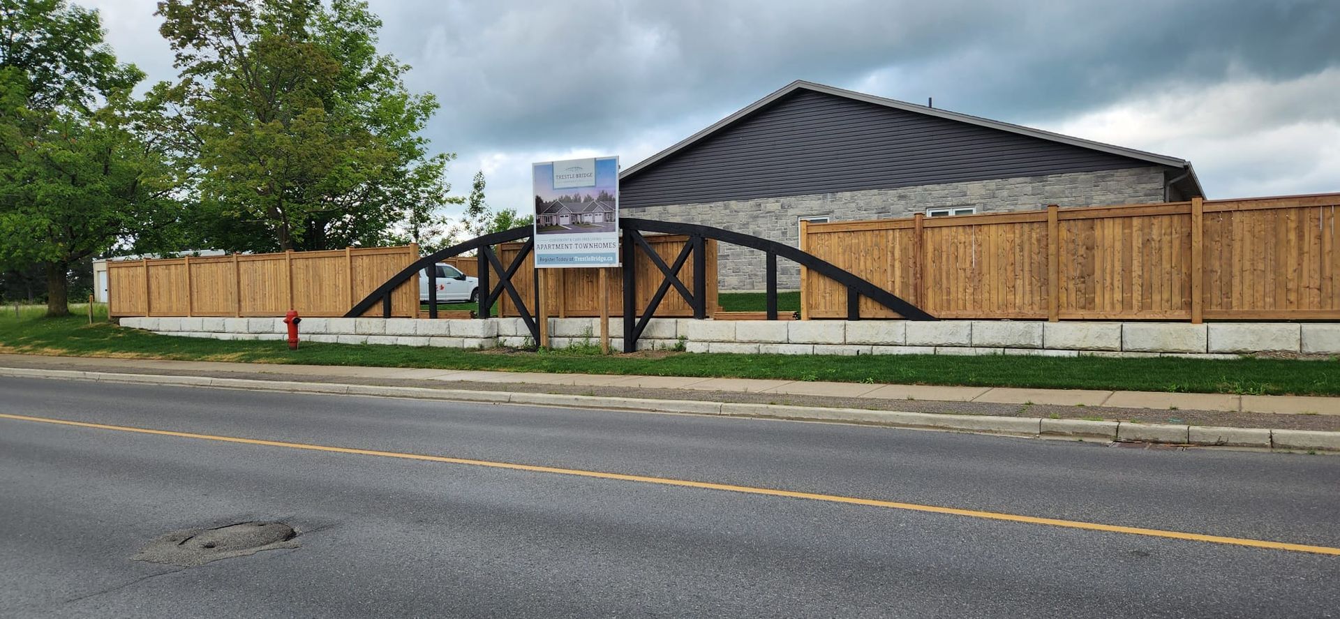 A wooden fence is surrounding a house under construction.