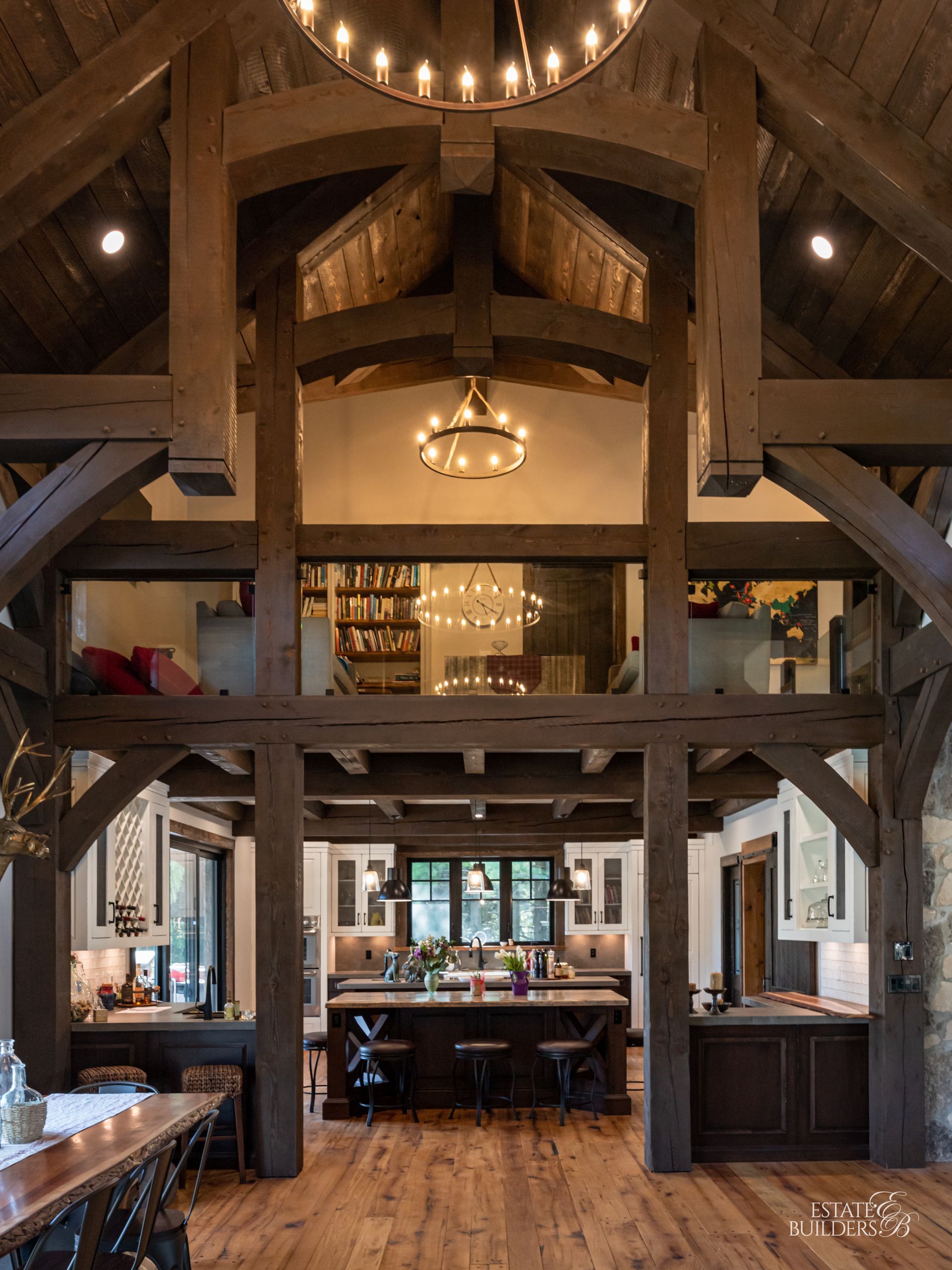 A large house with a timber frame porch and red chairs in front of it