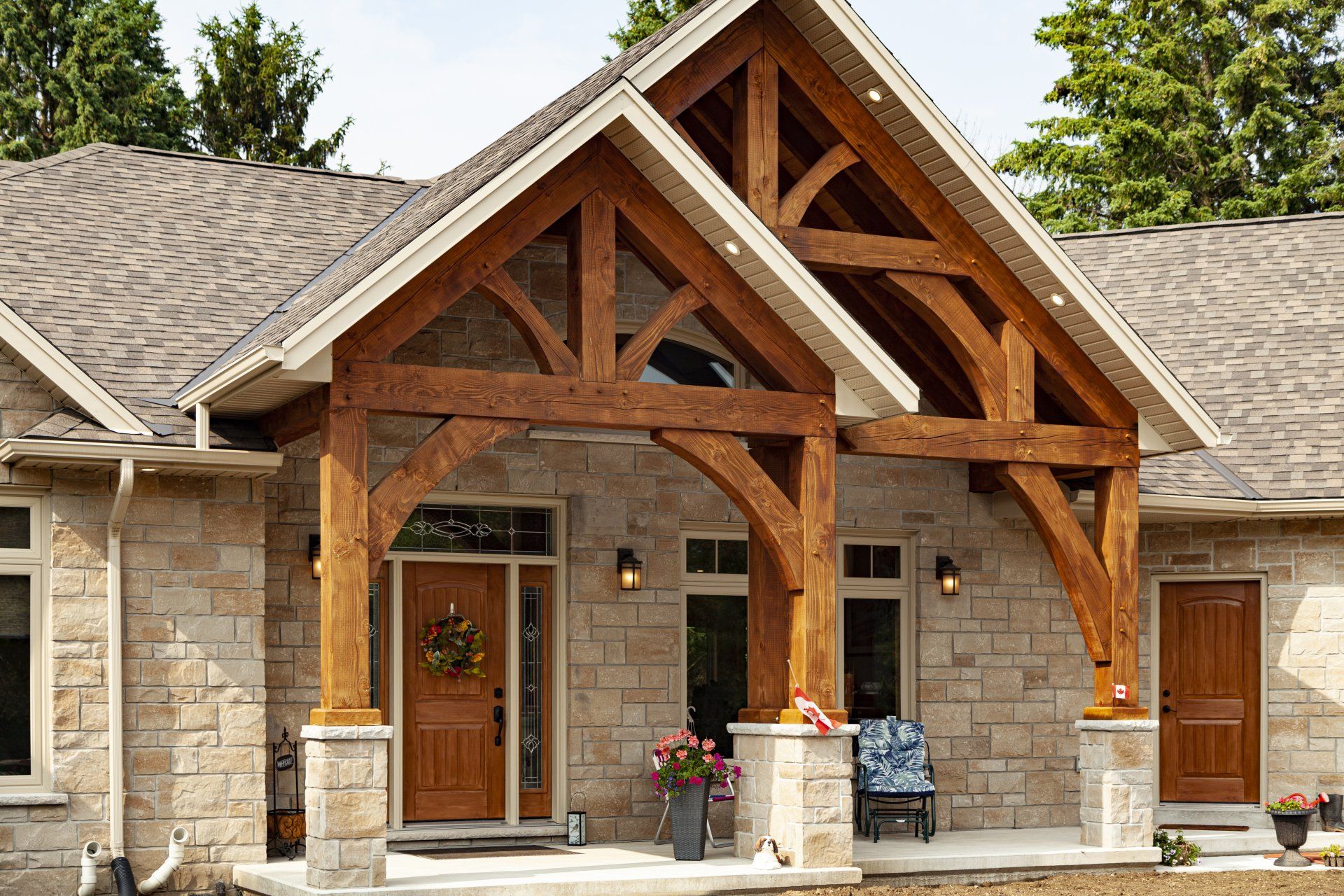 A large stone house with a wooden timber frame porch and a wooden roof.