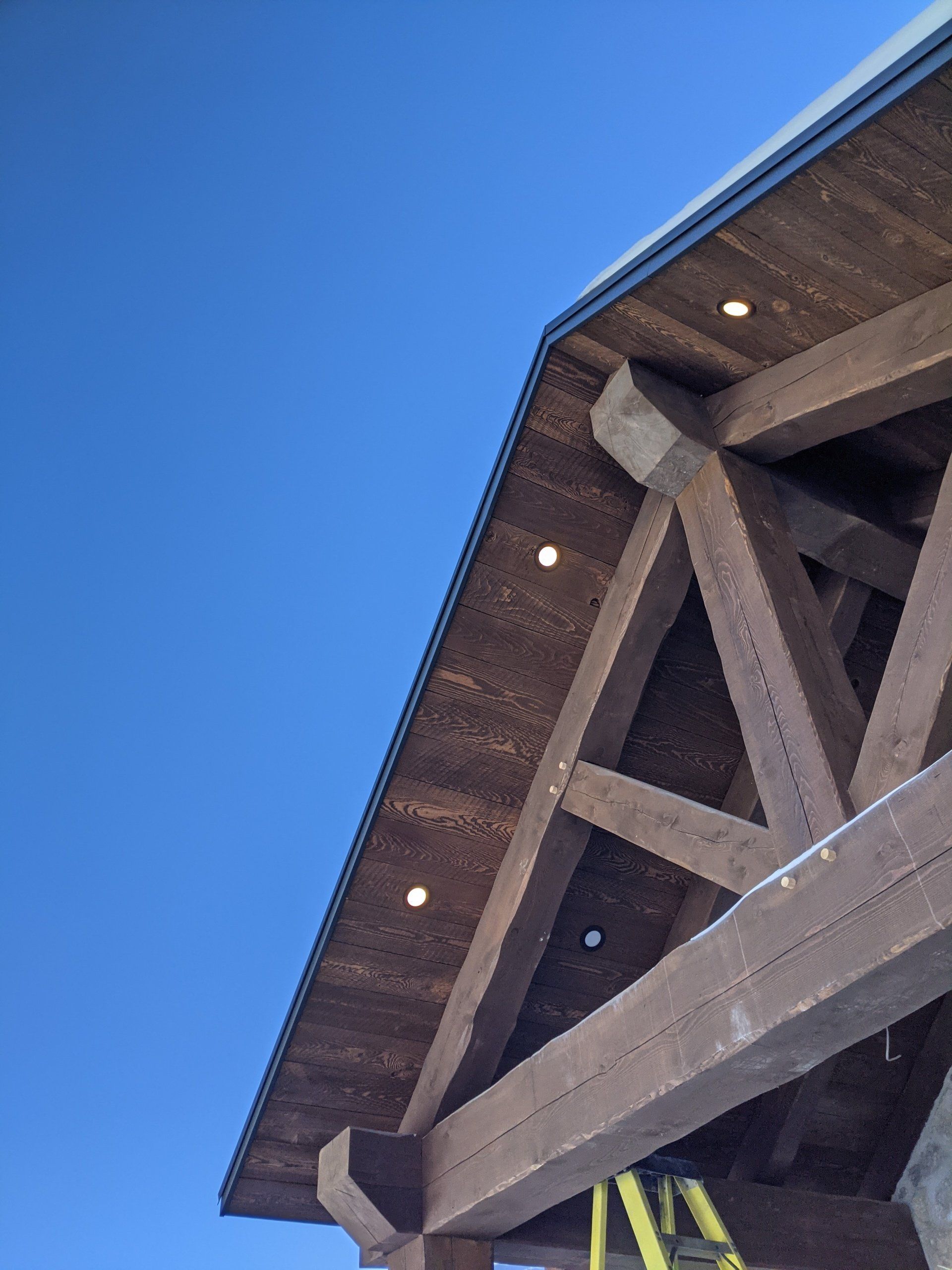 A wooden timber frame structure with a blue sky in the background