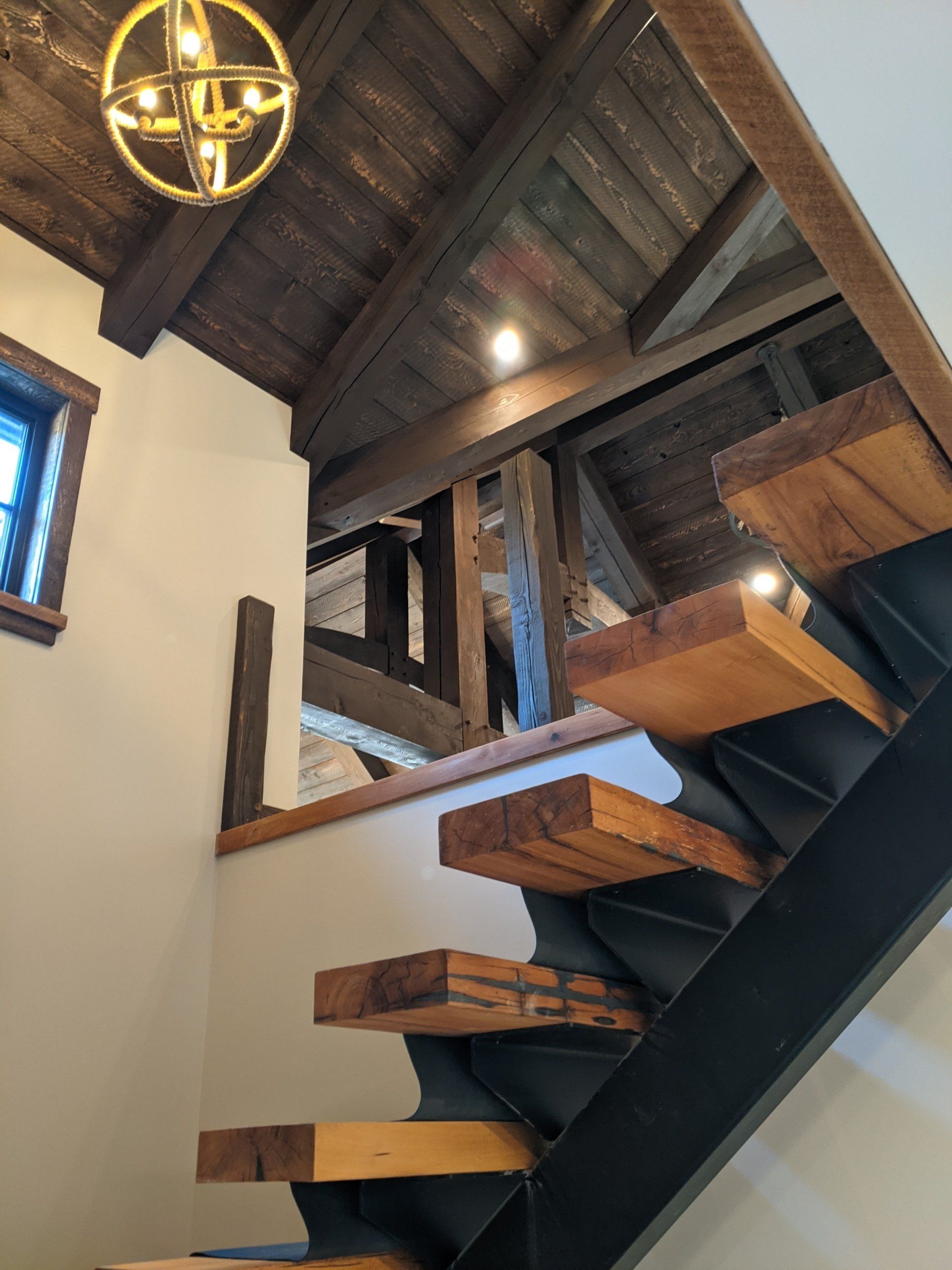 A staircase with wooden steps and a chandelier hanging from the ceiling
