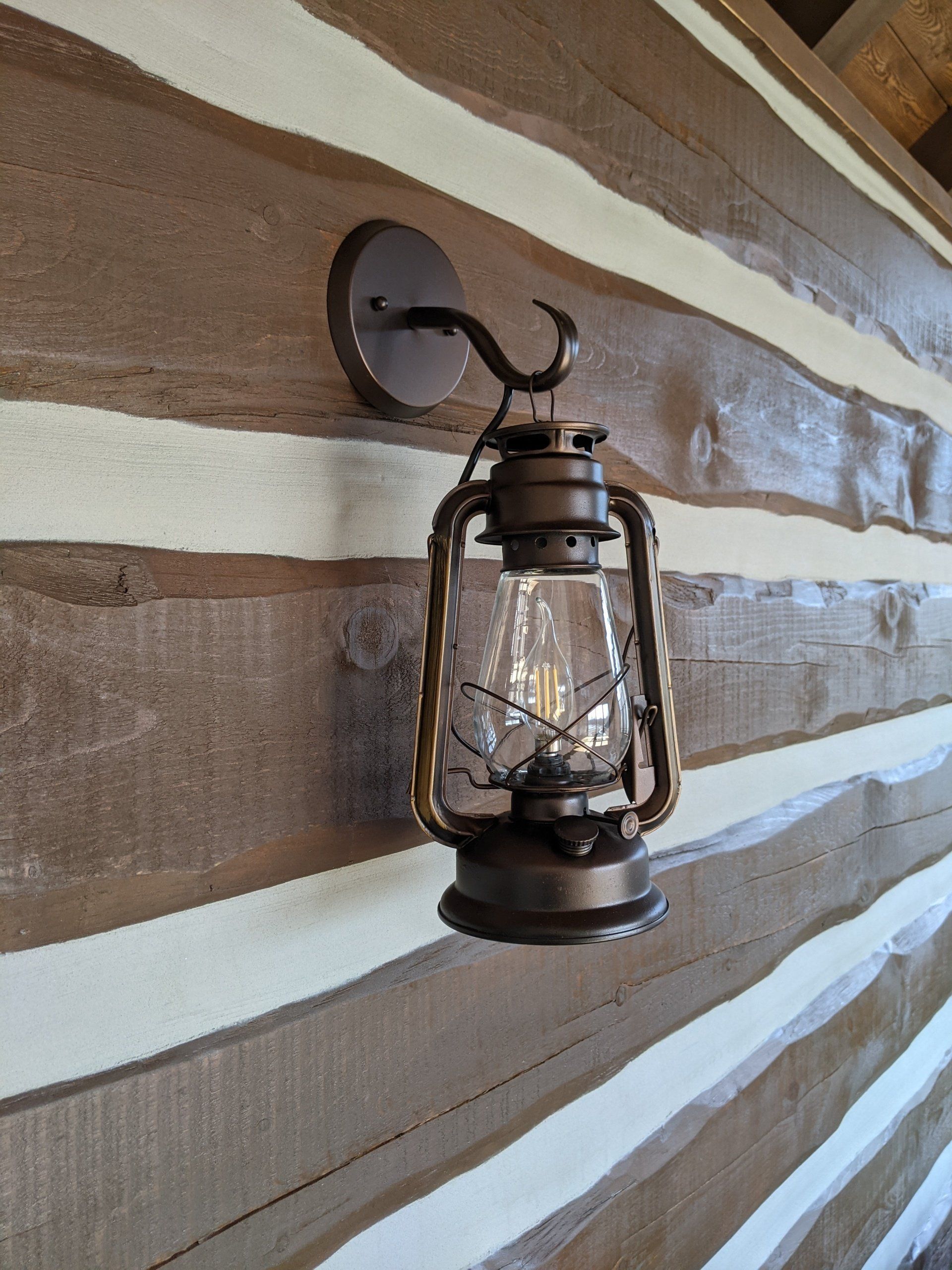 A lantern is hanging on a wooden wall.
