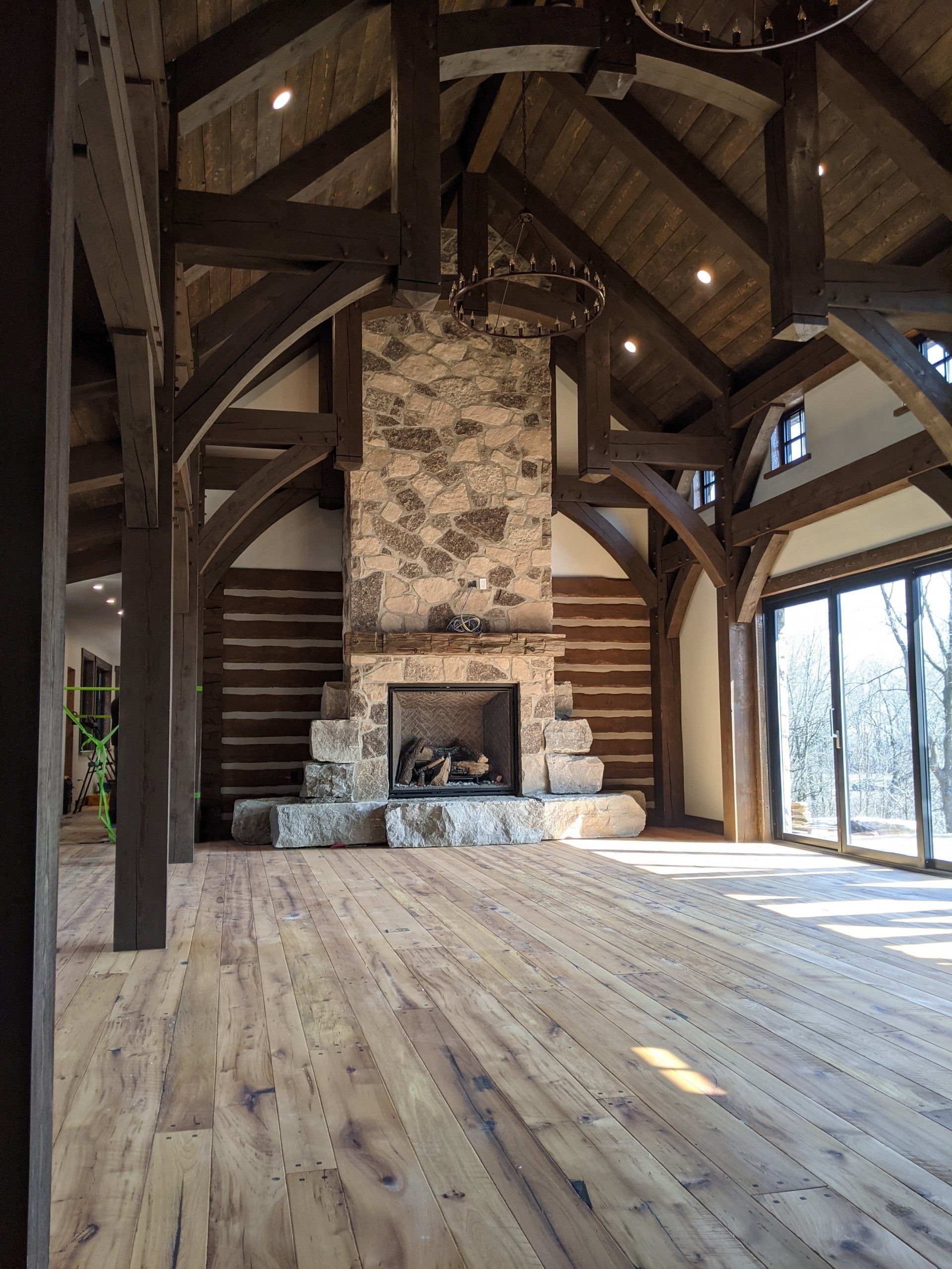 A large room with a fireplace and wooden timber frame beams