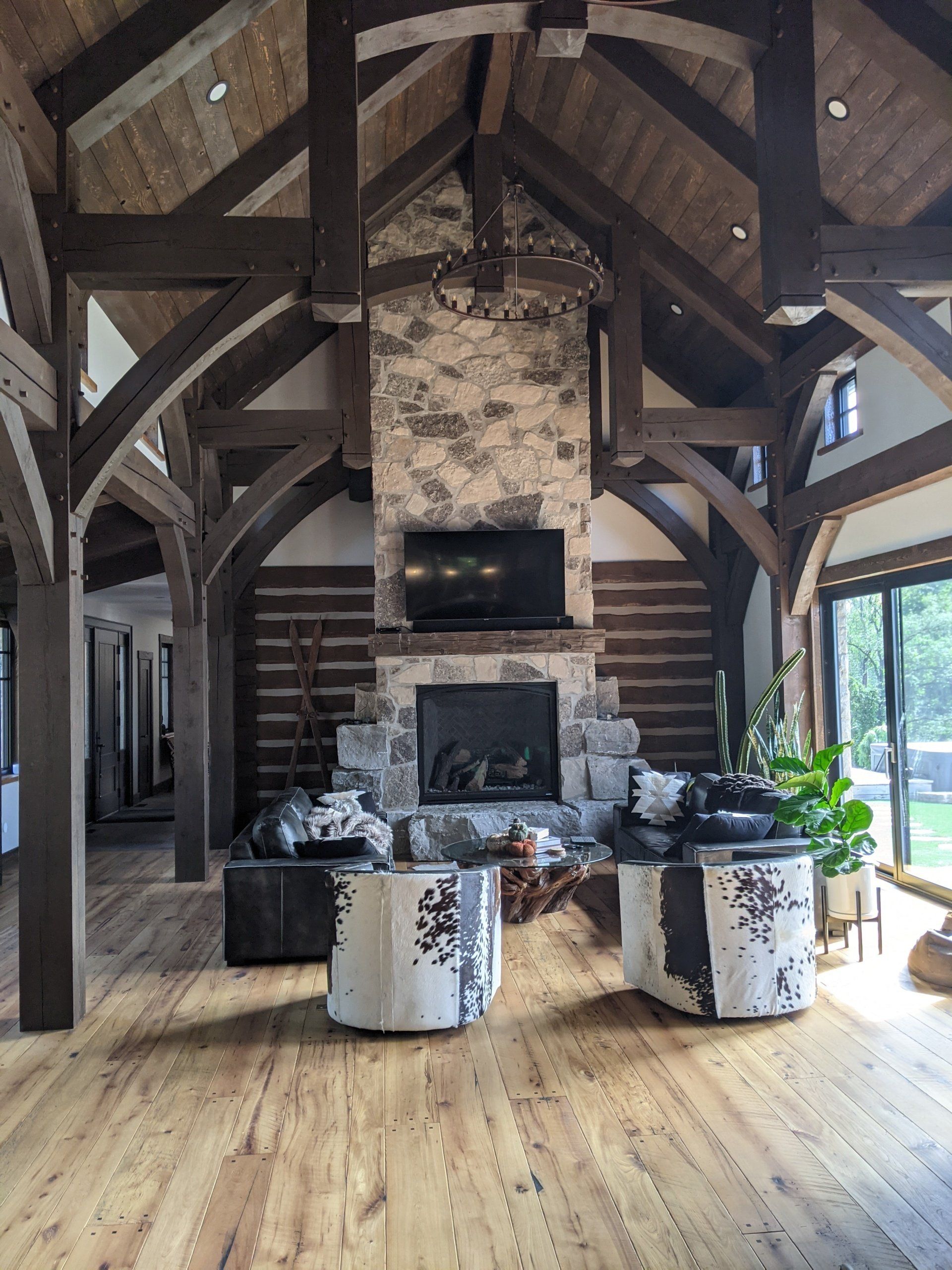 A living room in a log cabin with a fireplace and chairs