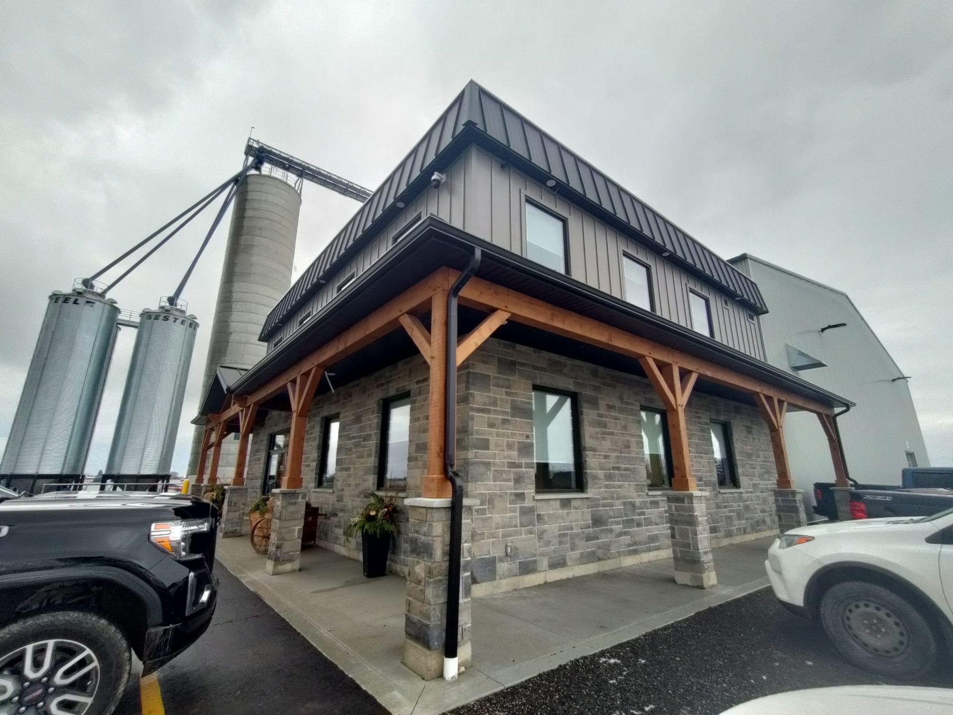 A building with a timber frame porch and a lot of cars parked in front of it.