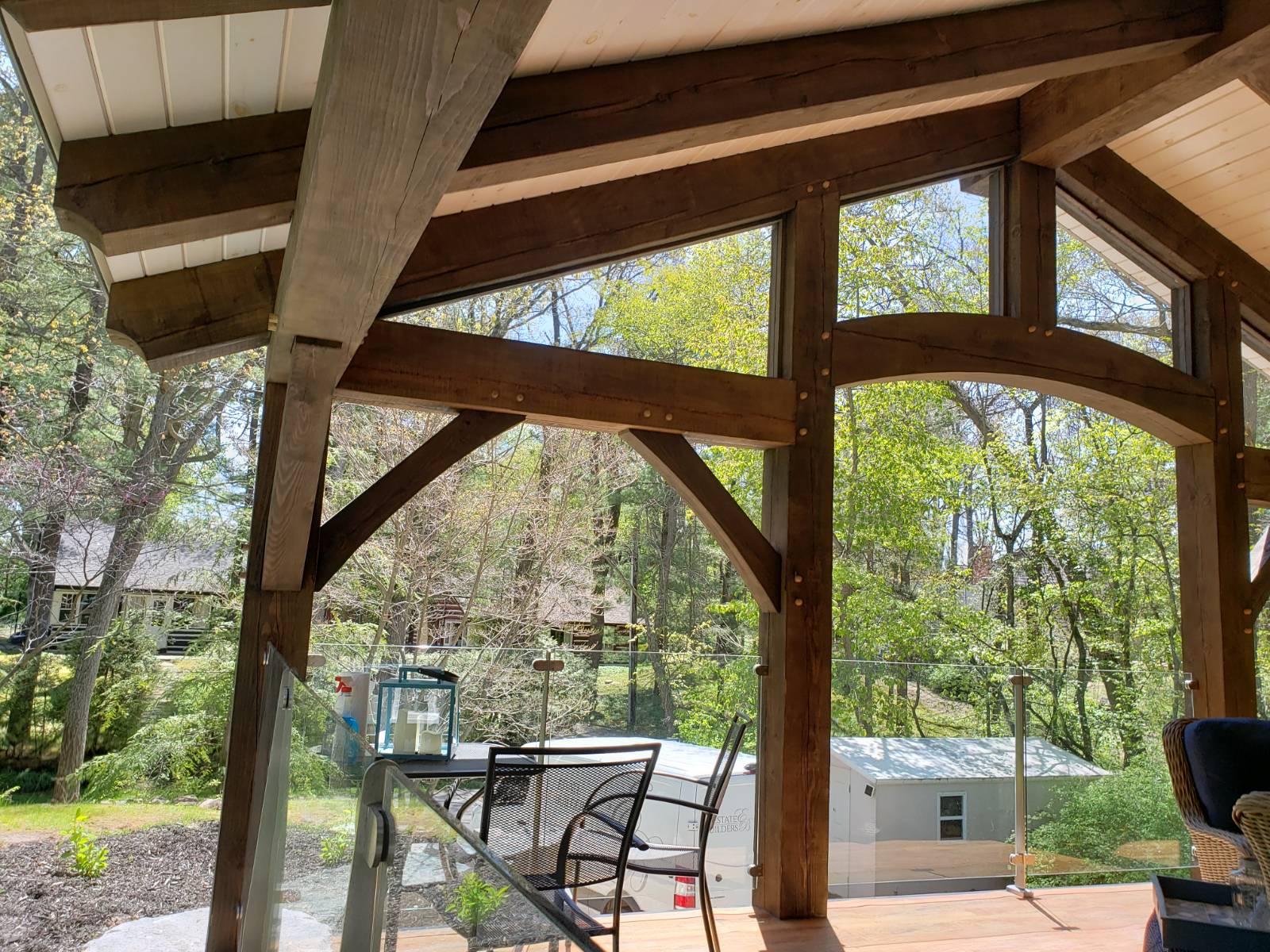 The inside of a house with a lot of windows and wooden timber frame beams.