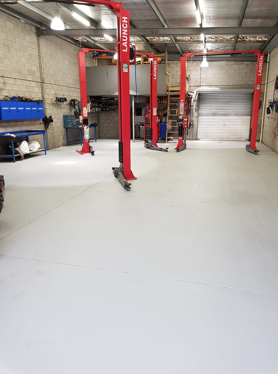 Garage Interior With Four Red Car Lifts. White Floor — COOTA Automotive Services in Ballarat East, VIC