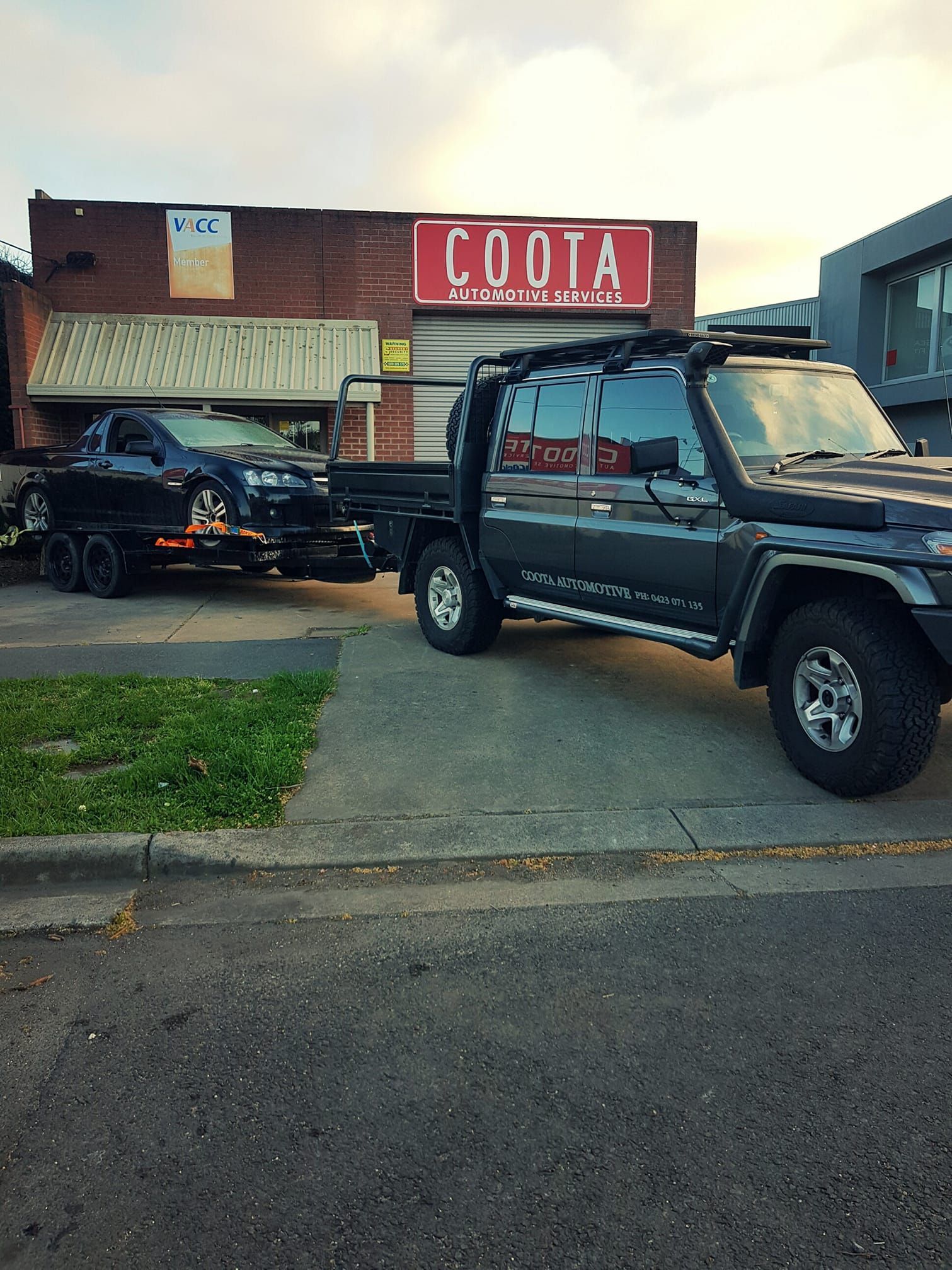 Dark Pickup Truck Towing a Car on a Trailer — COOTA Automotive Services in Ballarat East, VIC