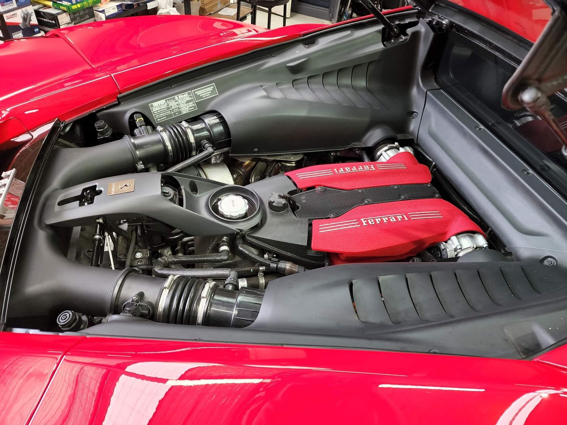 Red Ferrari engine bay, showing the engine, air intake, and red engine cover. — COOTA Automotive Services in Ballarat East, VIC