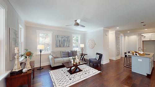Living room with gray sofa, area rug, and adjacent kitchen with island.
