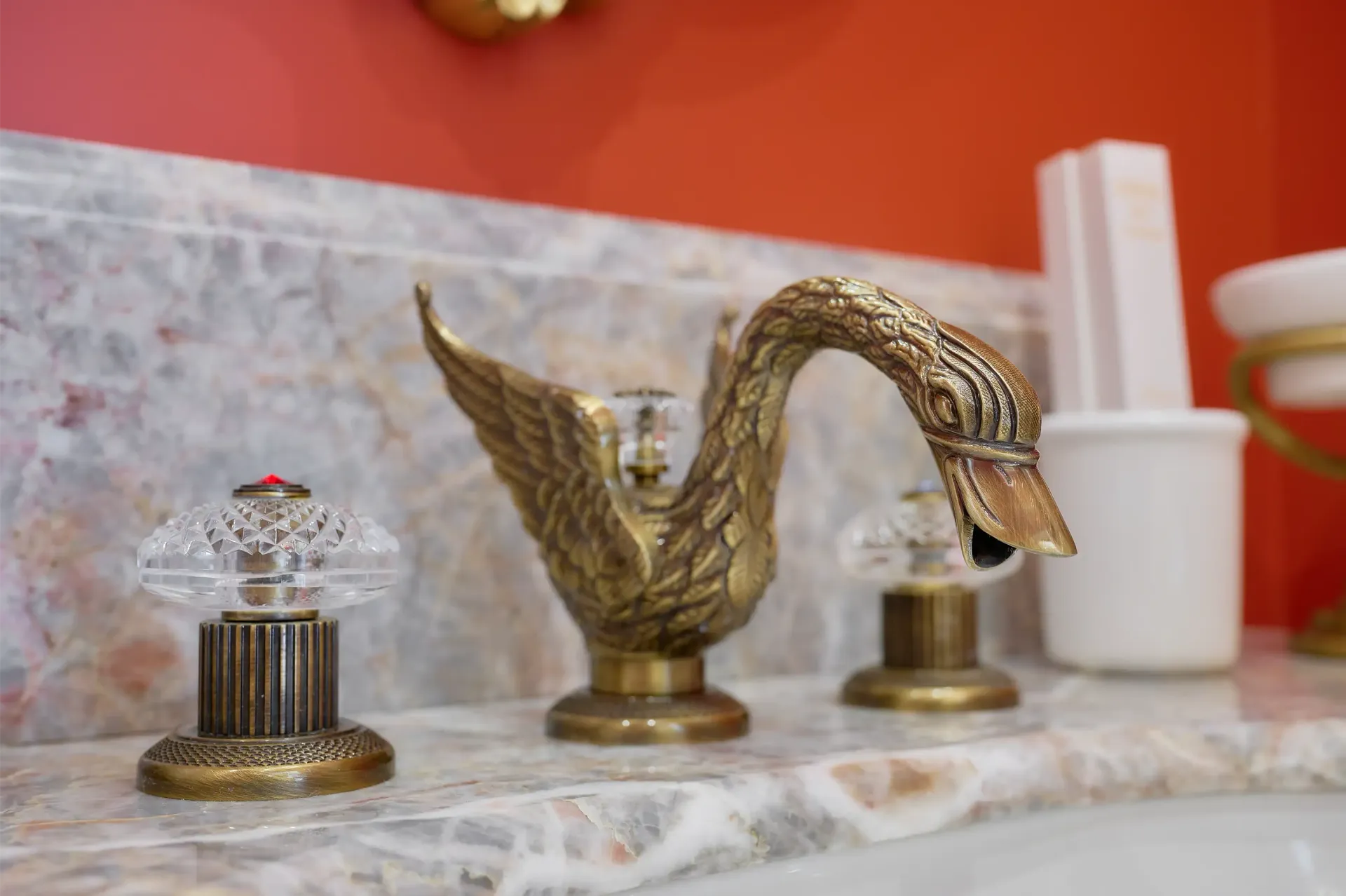 A bathroom sink with a faucet in the shape of a swan.