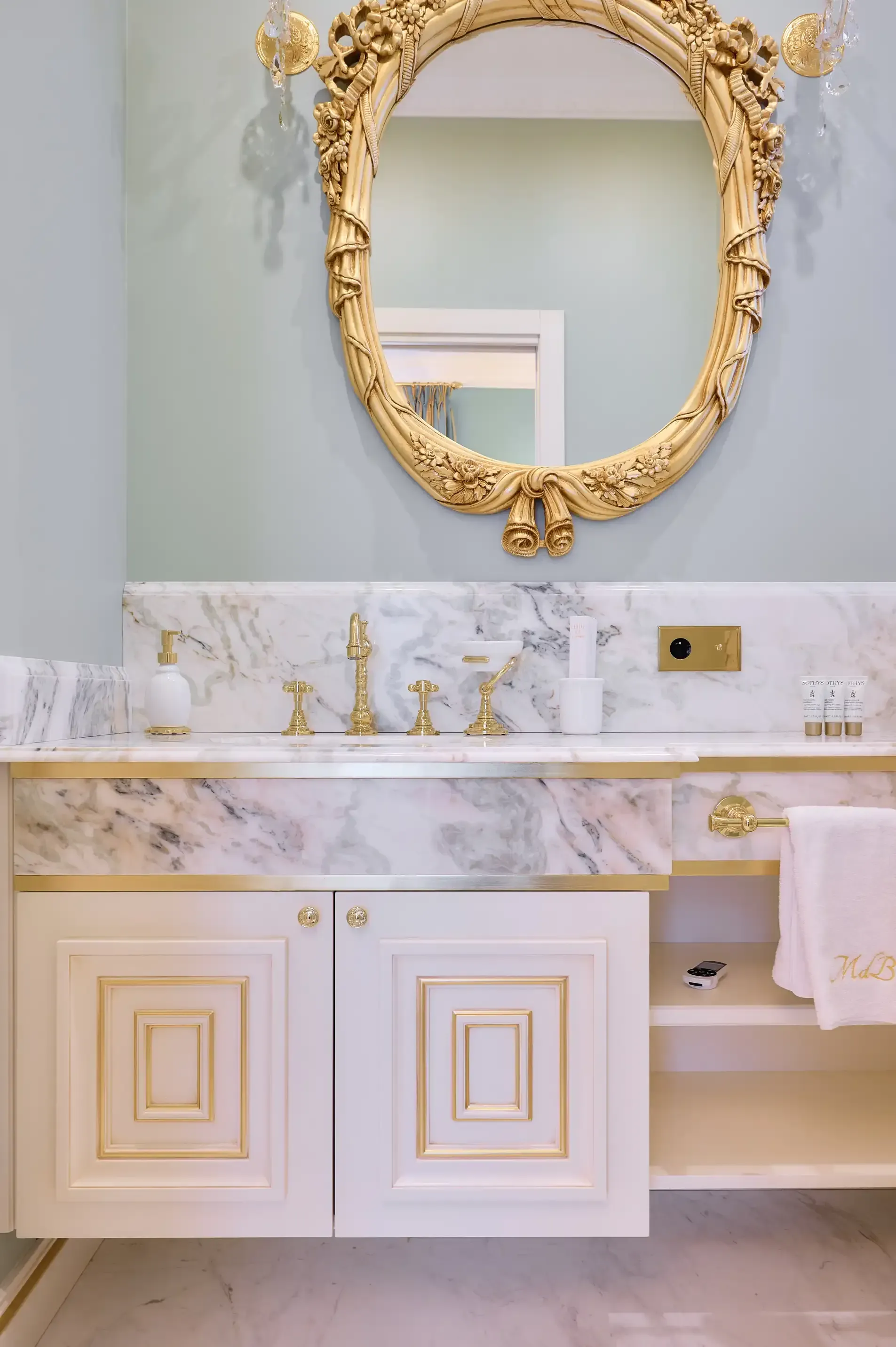 A bathroom with a sink , mirror and cabinets.