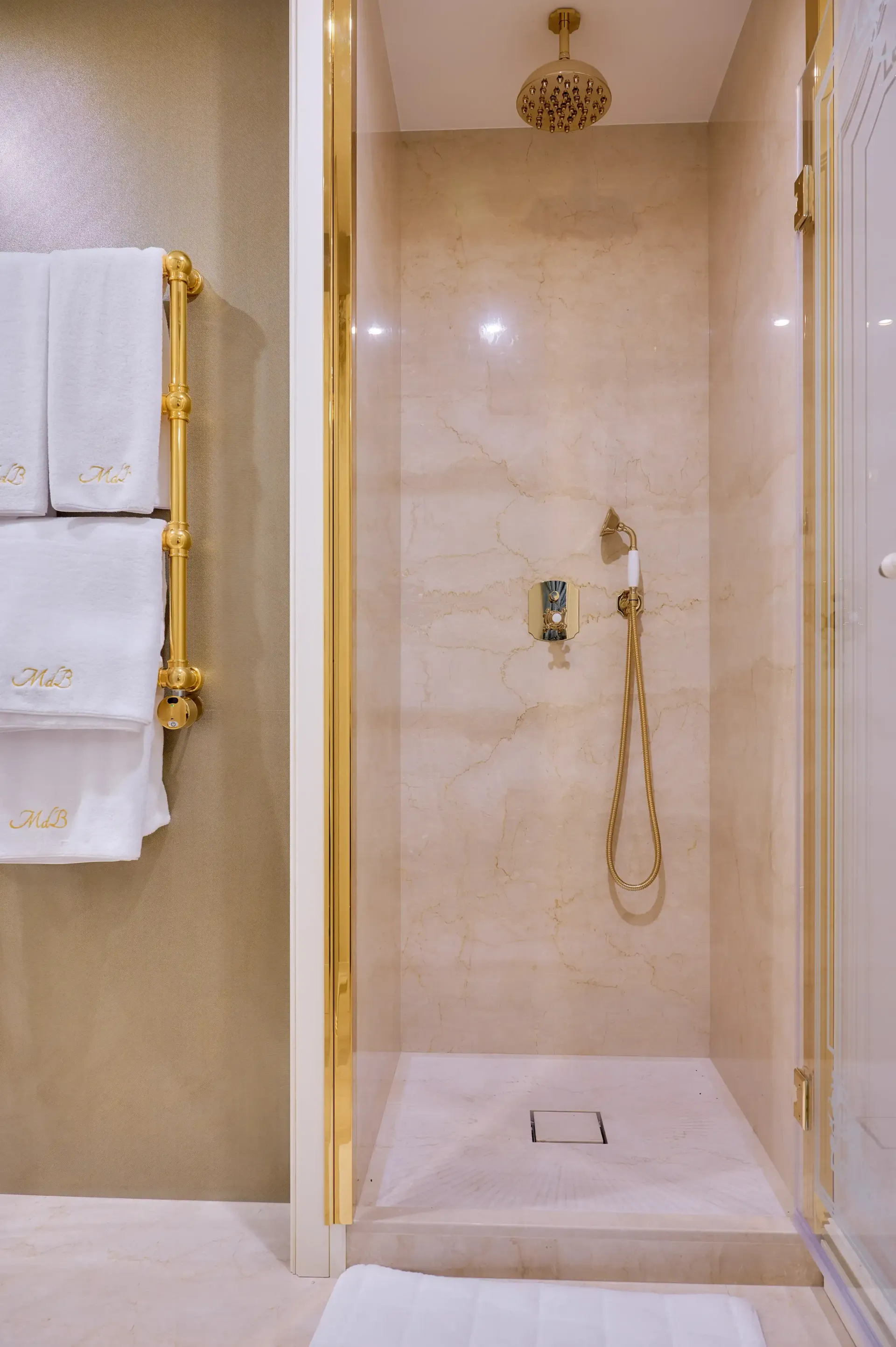 A bathroom with a walk in shower and a towel rack.