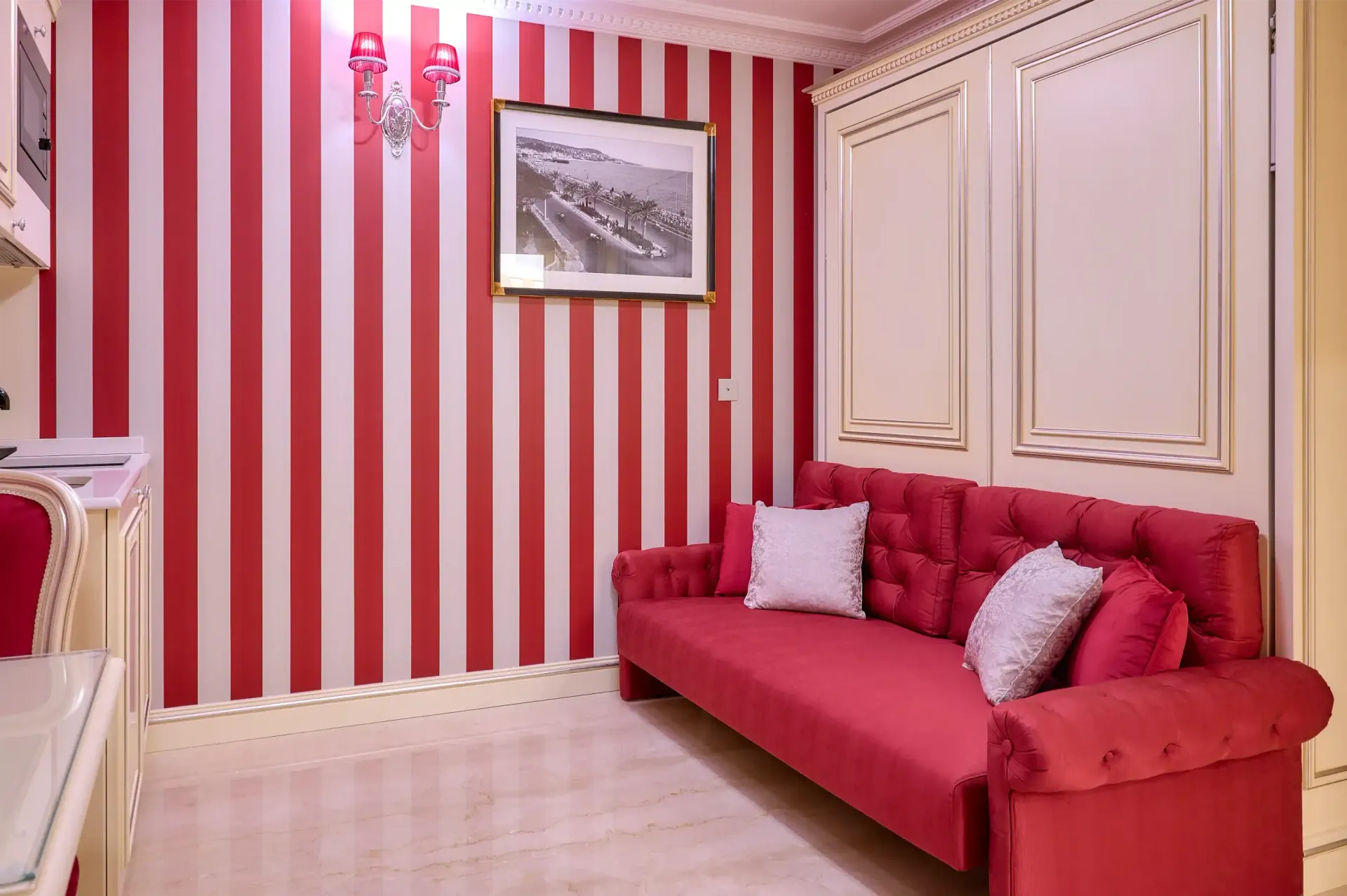 A living room with red and white striped walls and a red couch.