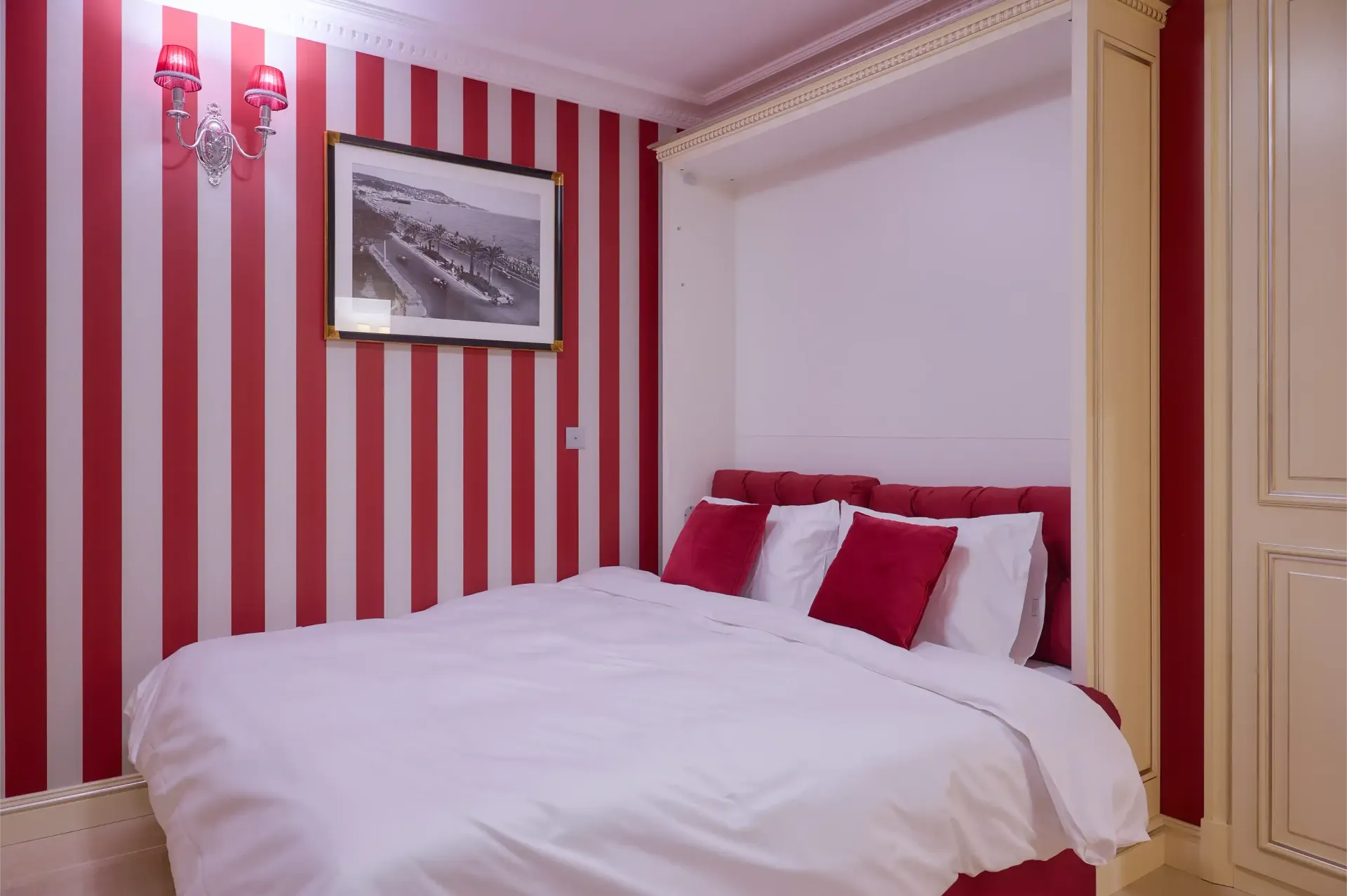 A bedroom with red and white striped walls and a bed.