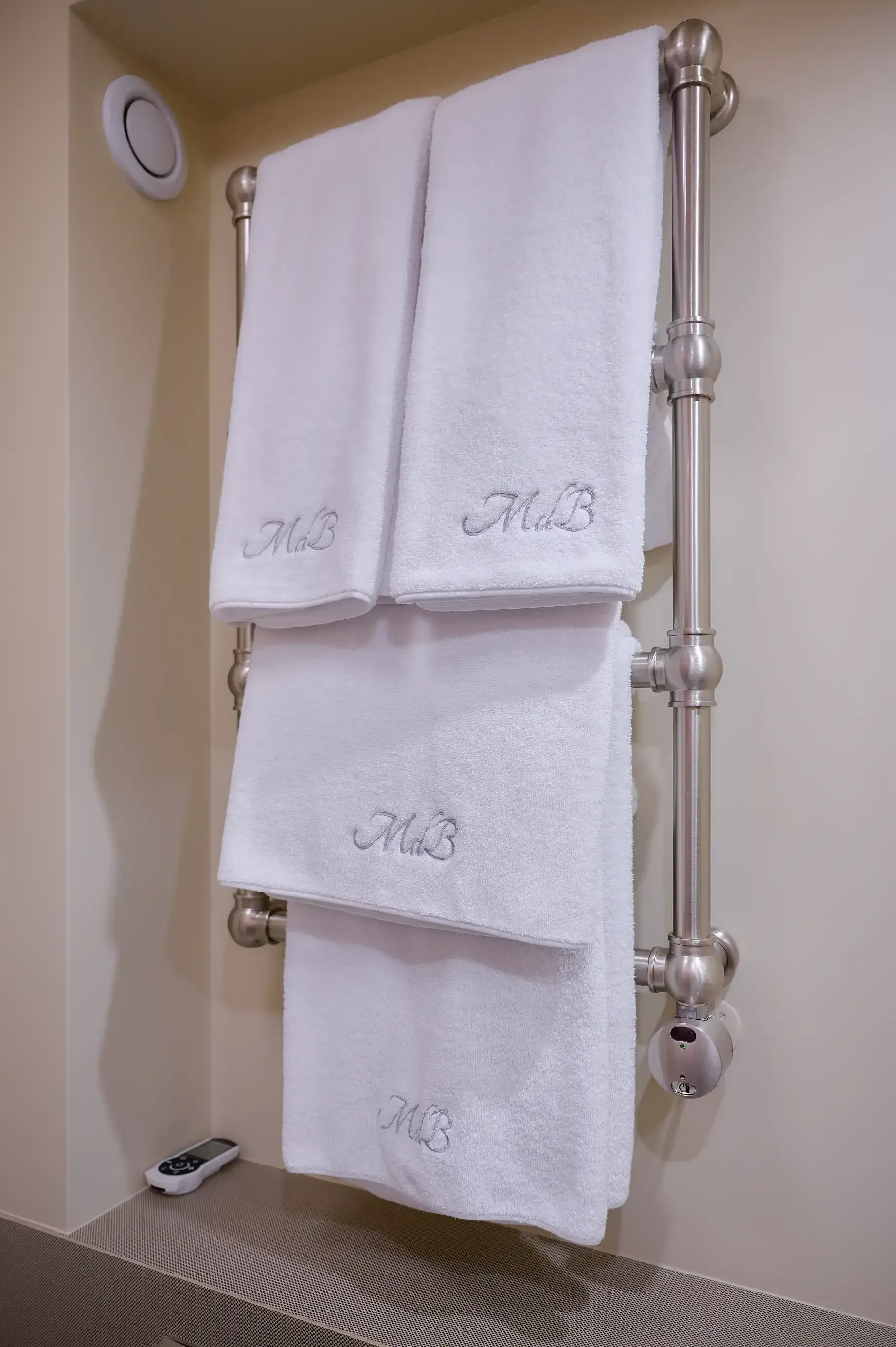 A stack of white towels hanging on a towel rack in a bathroom.