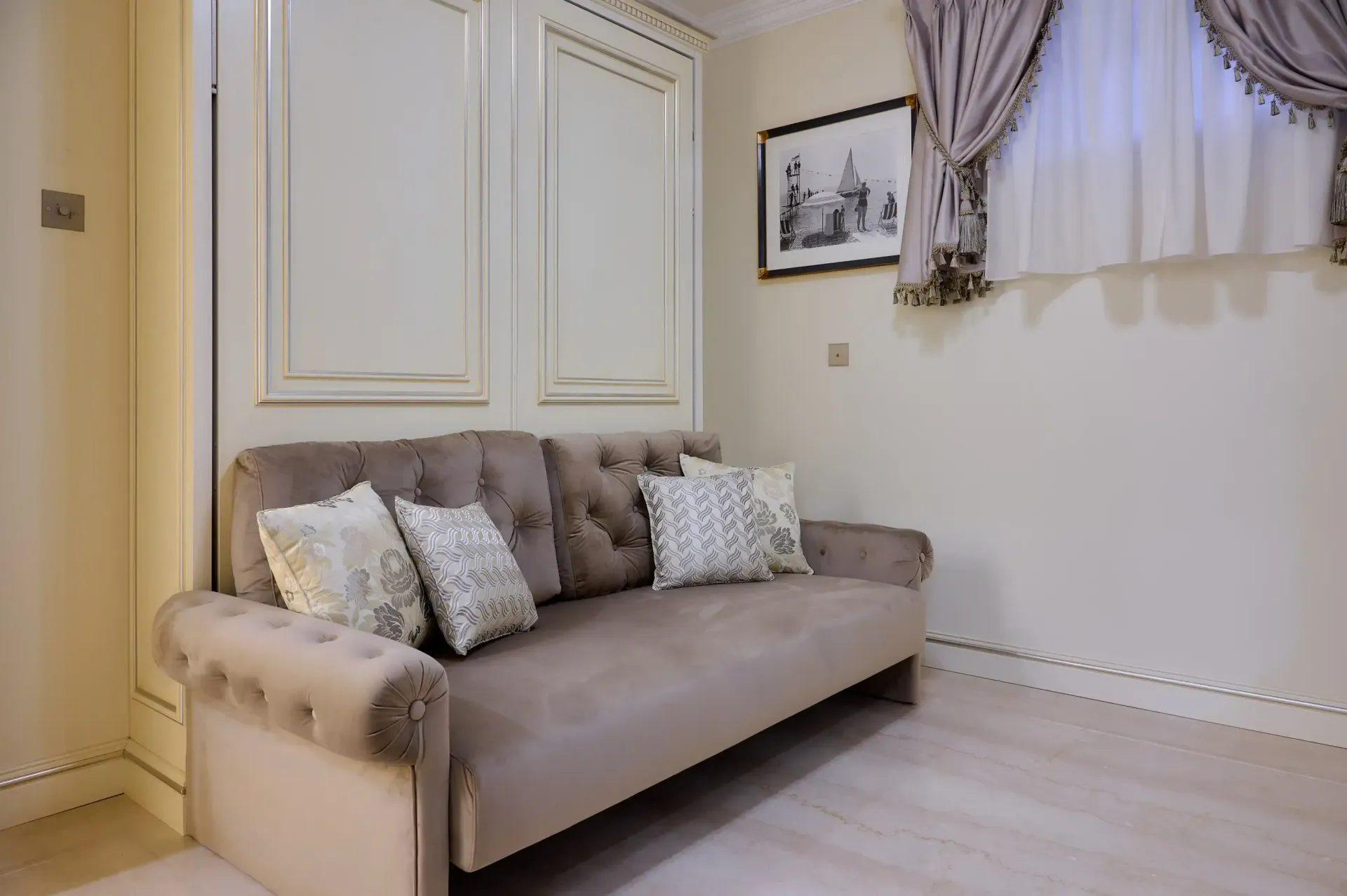 A living room with a couch and a picture on the wall.