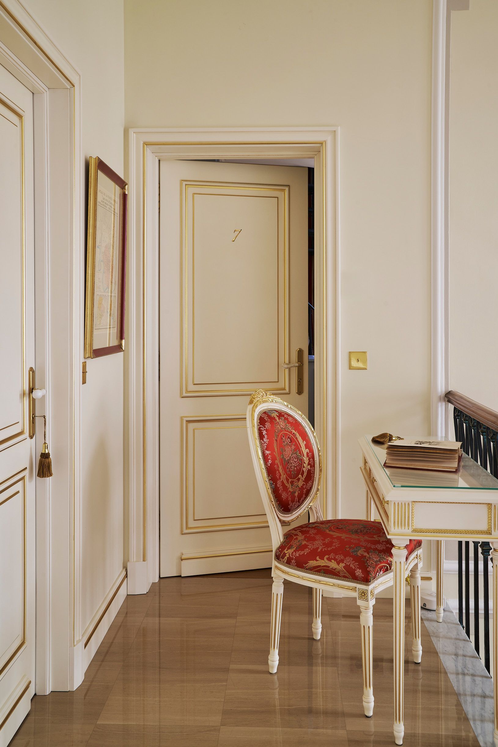 A white and gold room with a coat of arms on the wall.