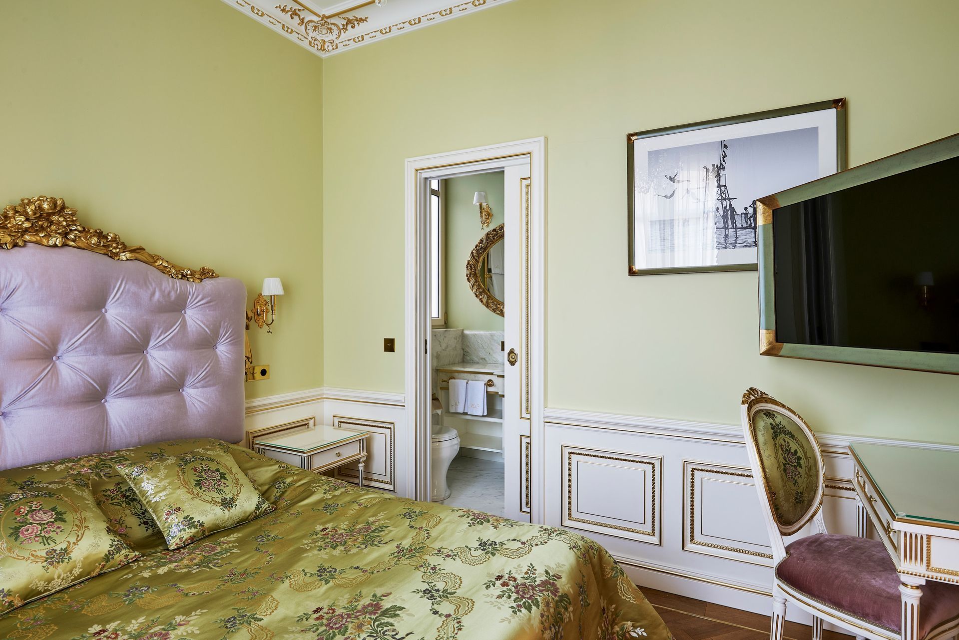 A bedroom with a bed , nightstands , and a purple headboard.