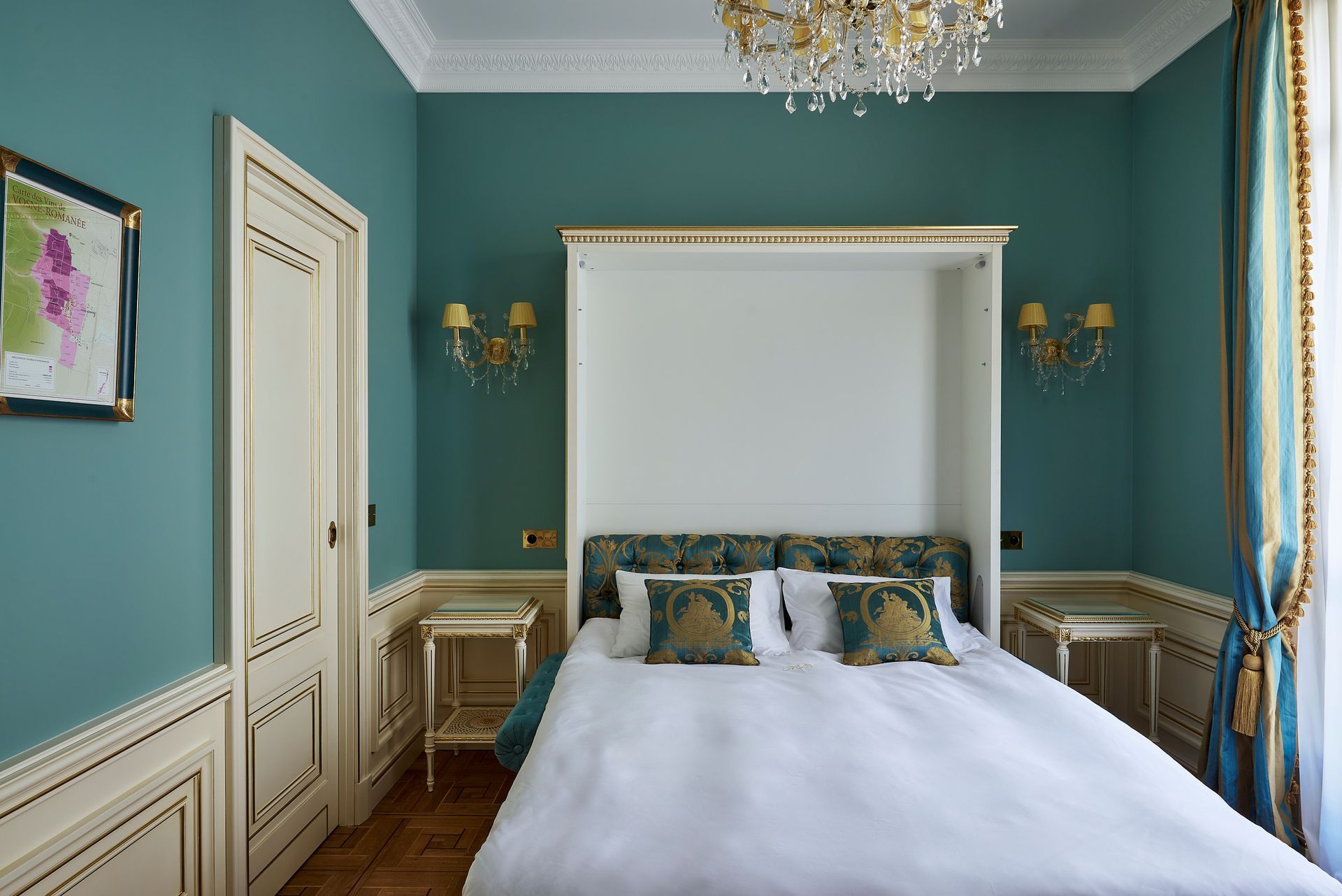 A bed with white sheets and blue pillows in a hotel room.