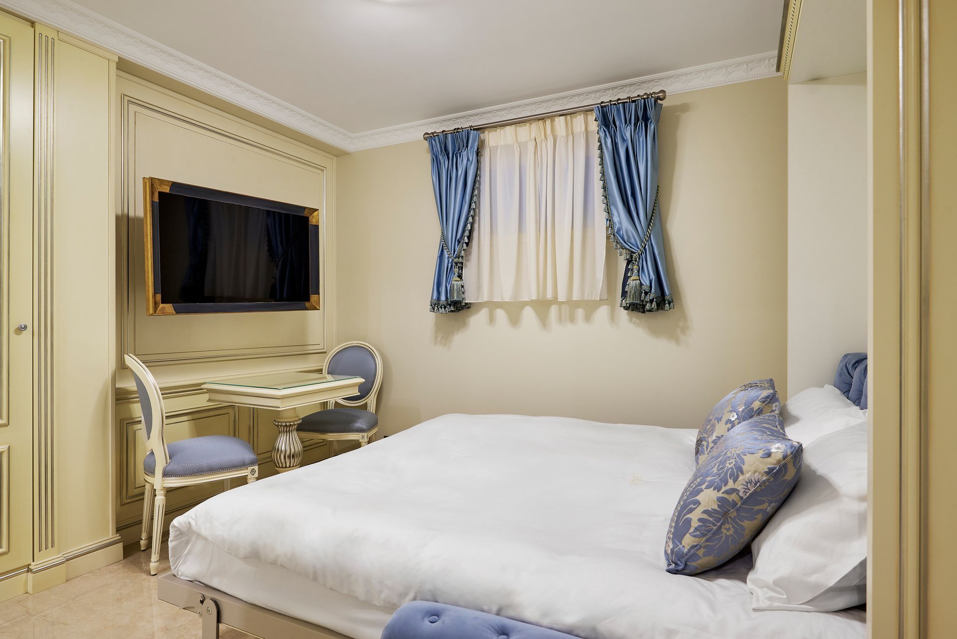 A bedroom with a bed , curtains and a window.