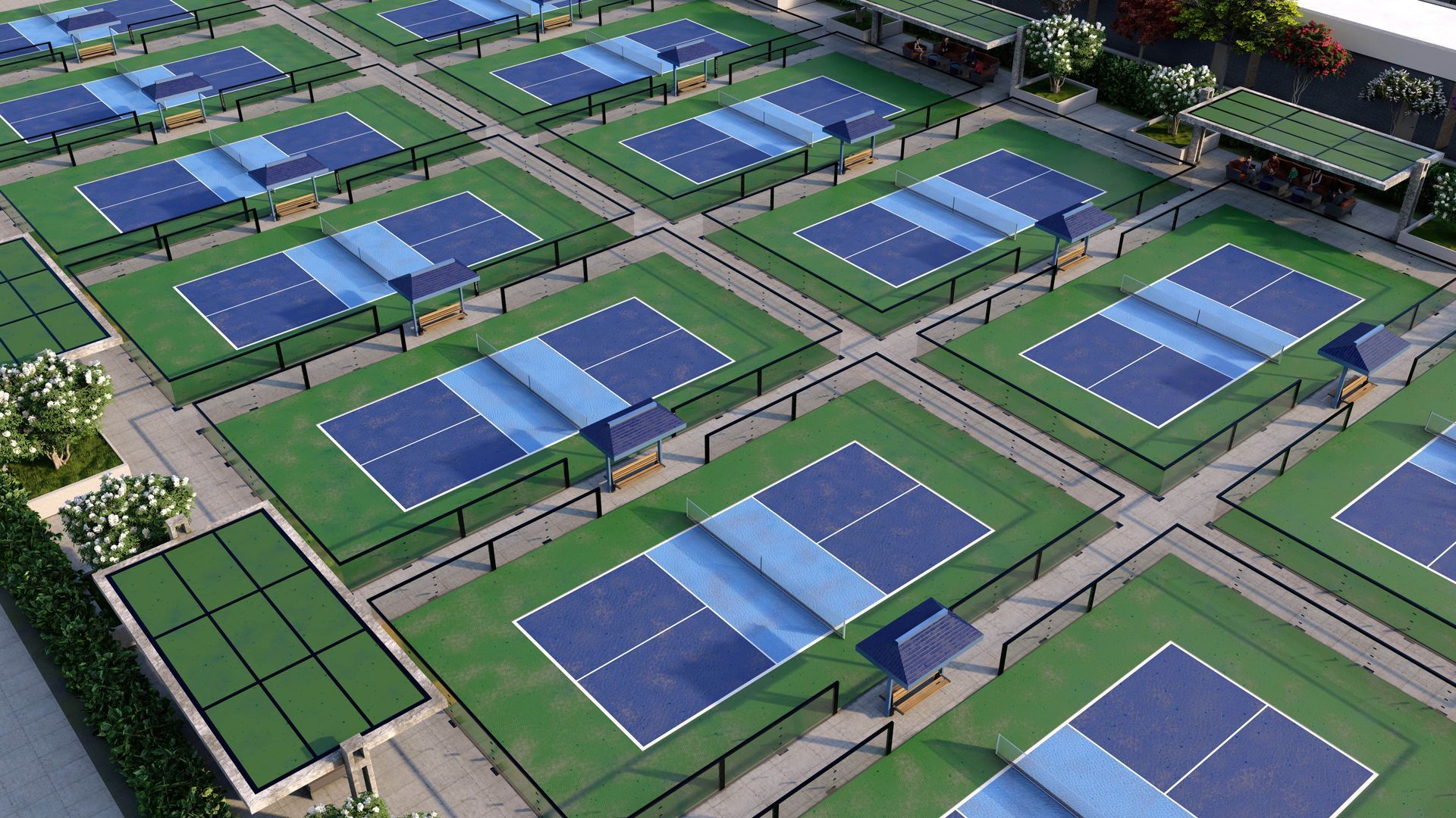 Outdoor pickleball courts with nets, surrounded by landscaping, under a sunny blue sky.