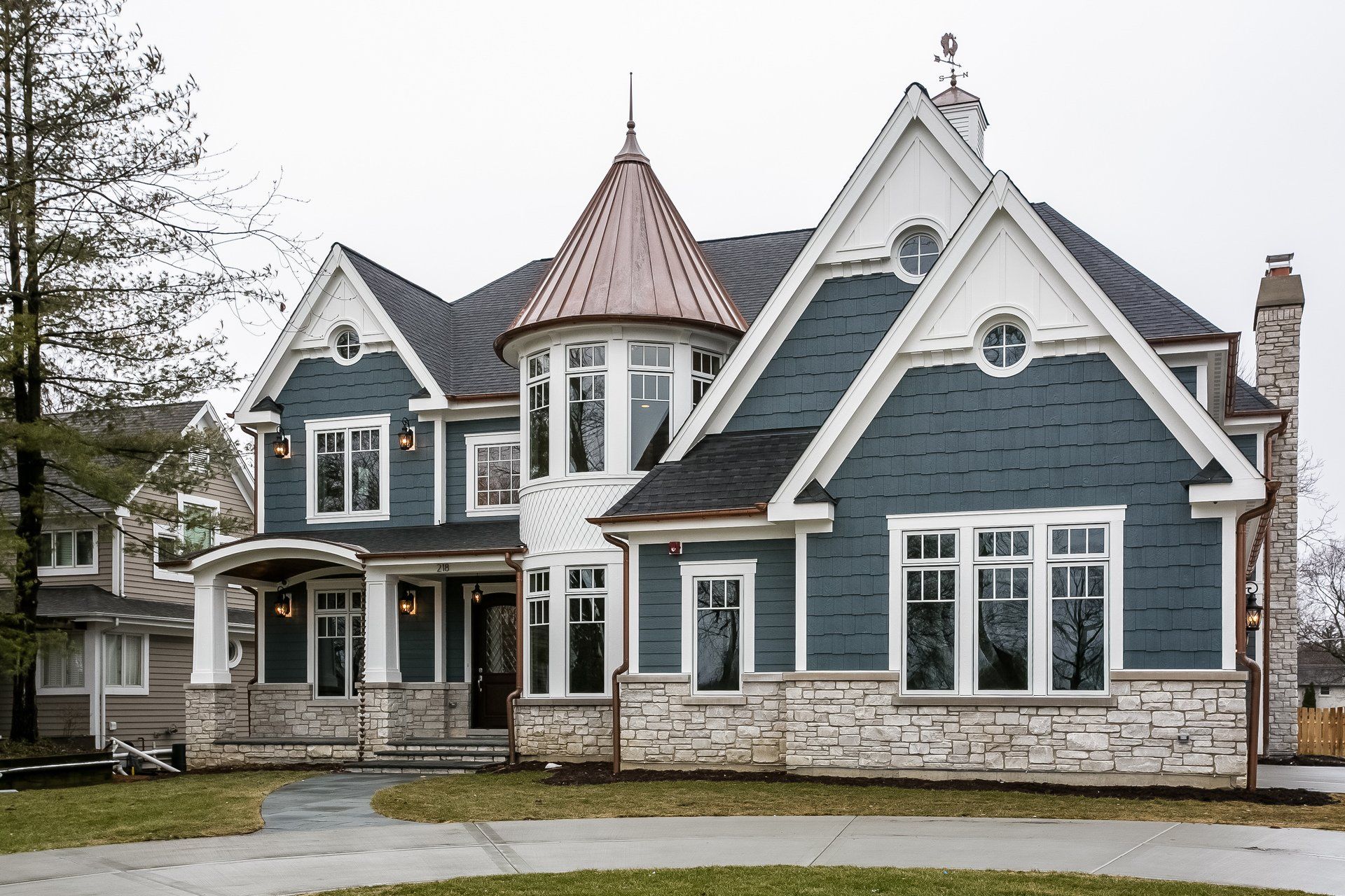 A large blue and white house with a copper roof