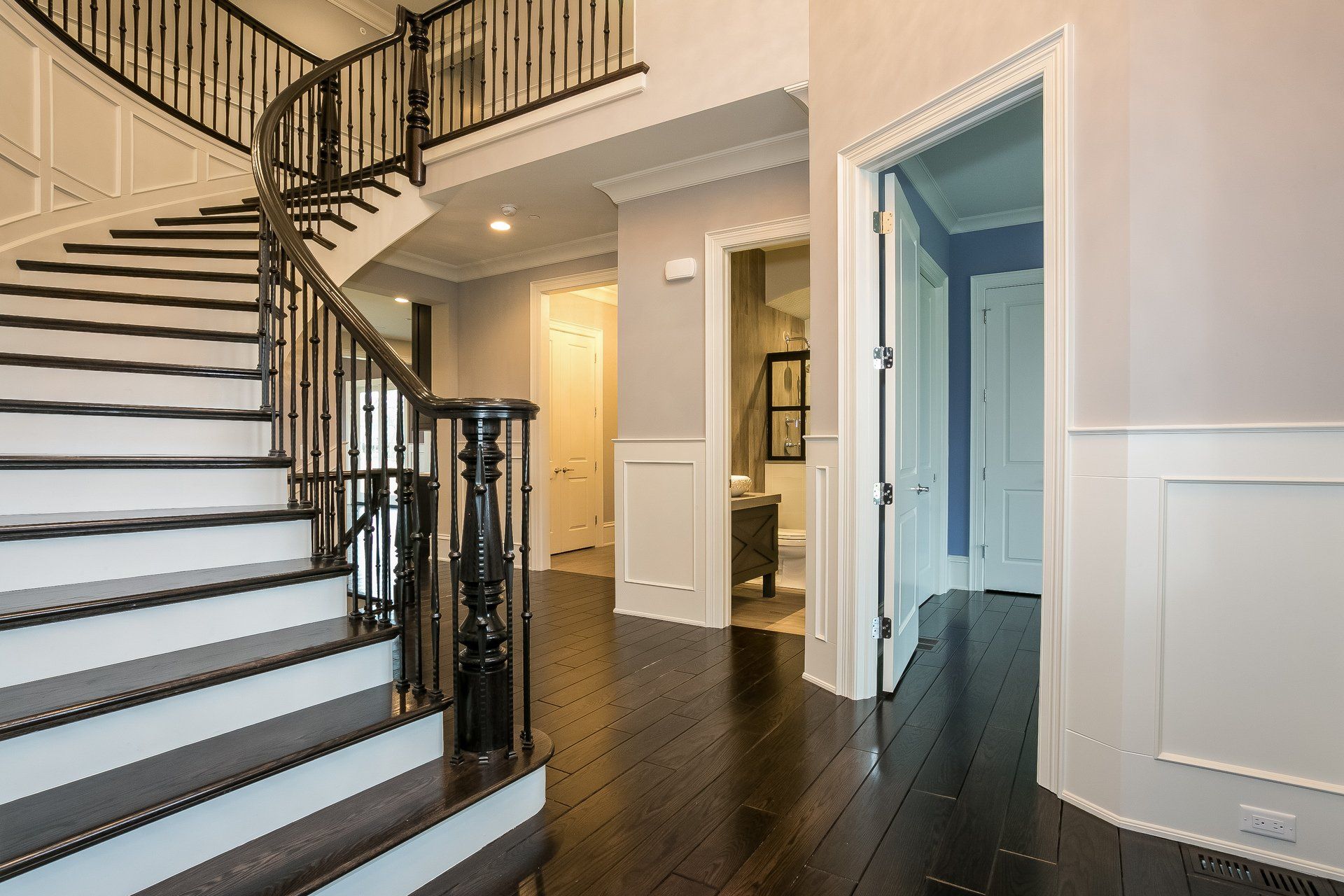 There is a staircase in the middle of the hallway leading up to the second floor.