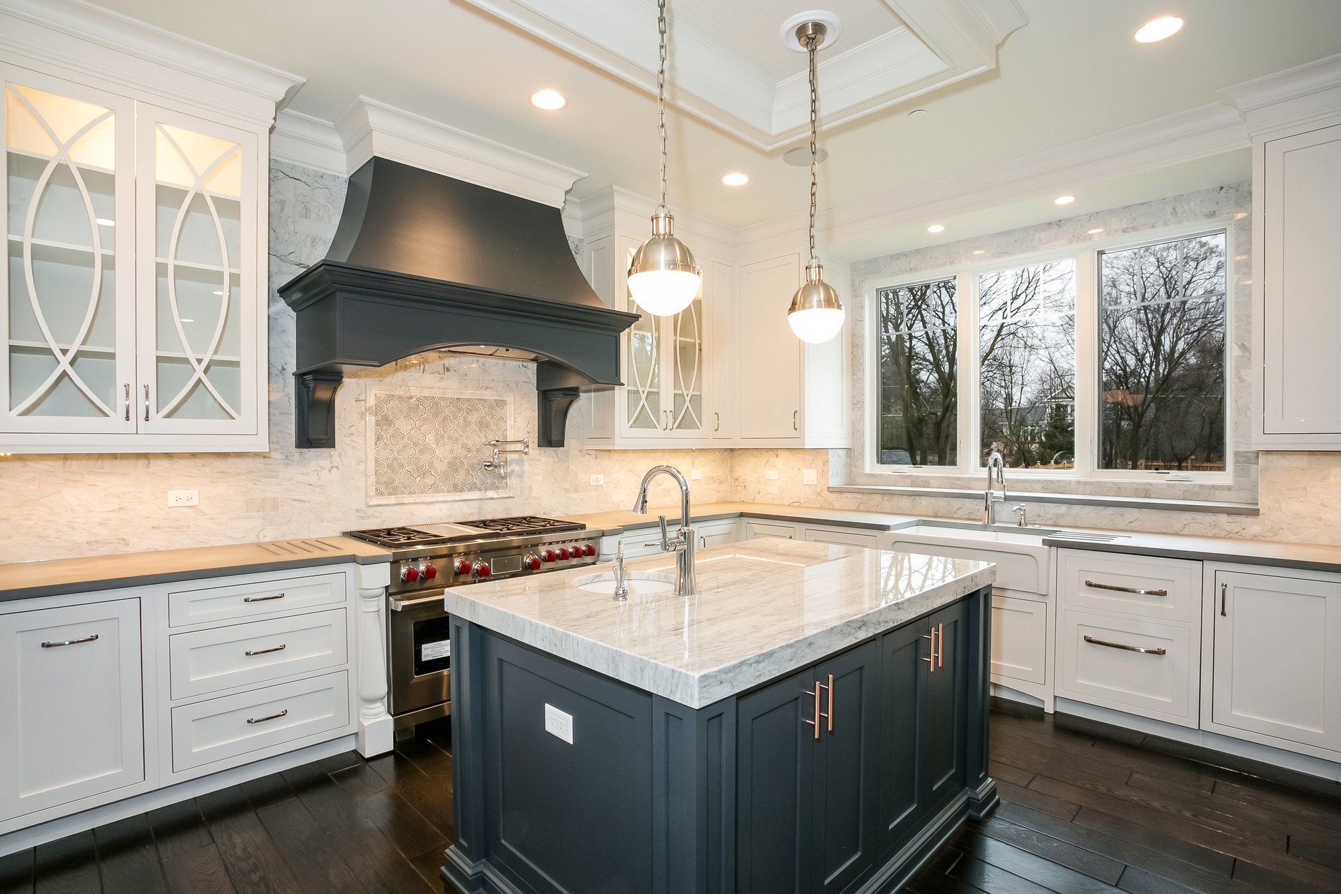A kitchen with white cabinets and a large island in the middle.
