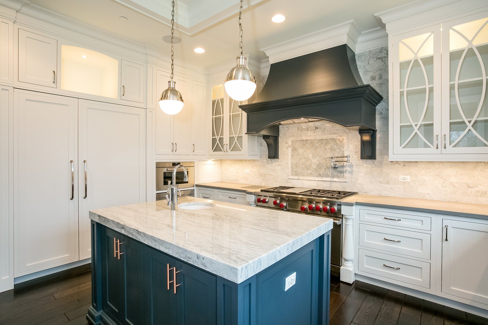 A kitchen with white cabinets and a large island in the middle.