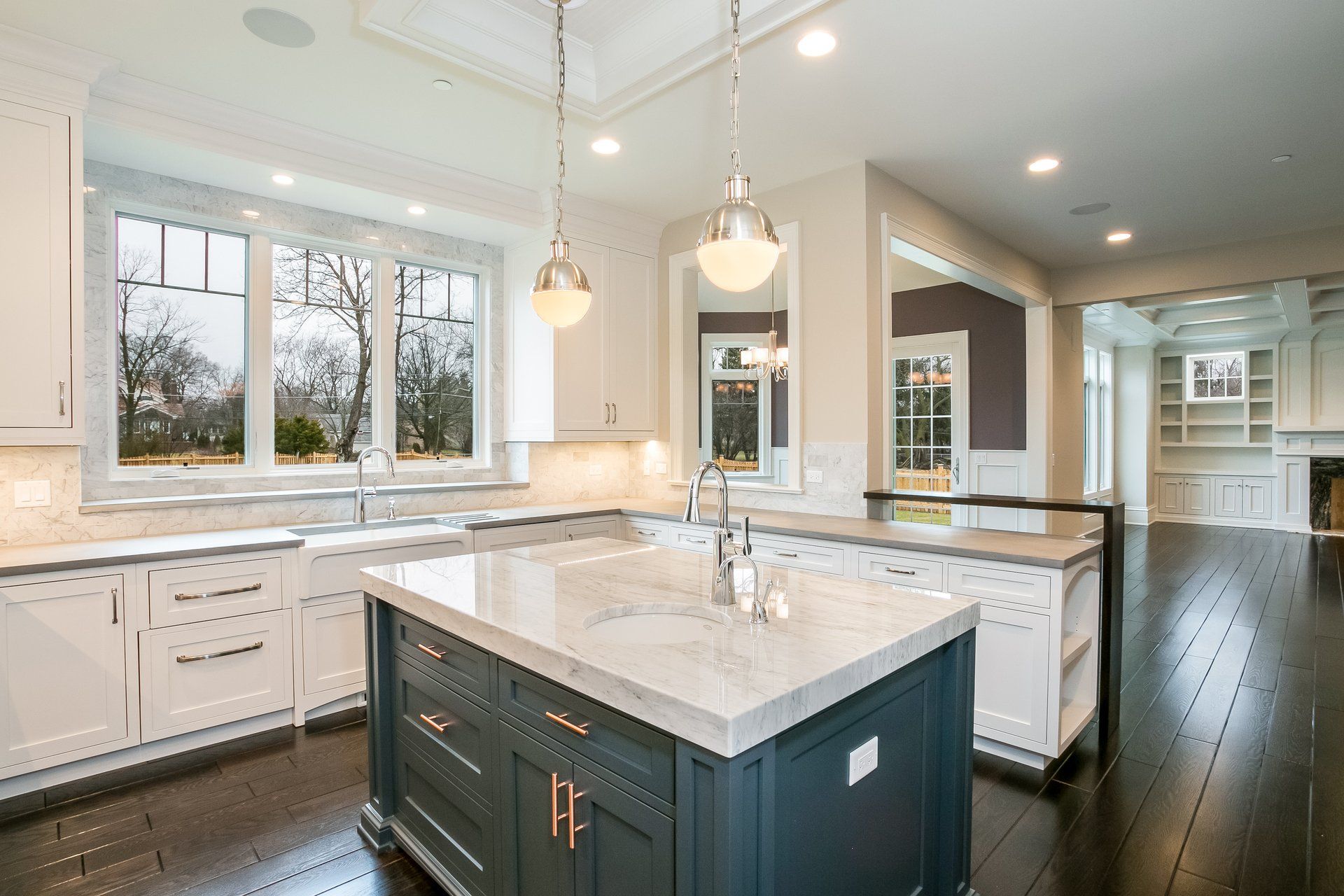 A kitchen with white cabinets and a large island in the middle.